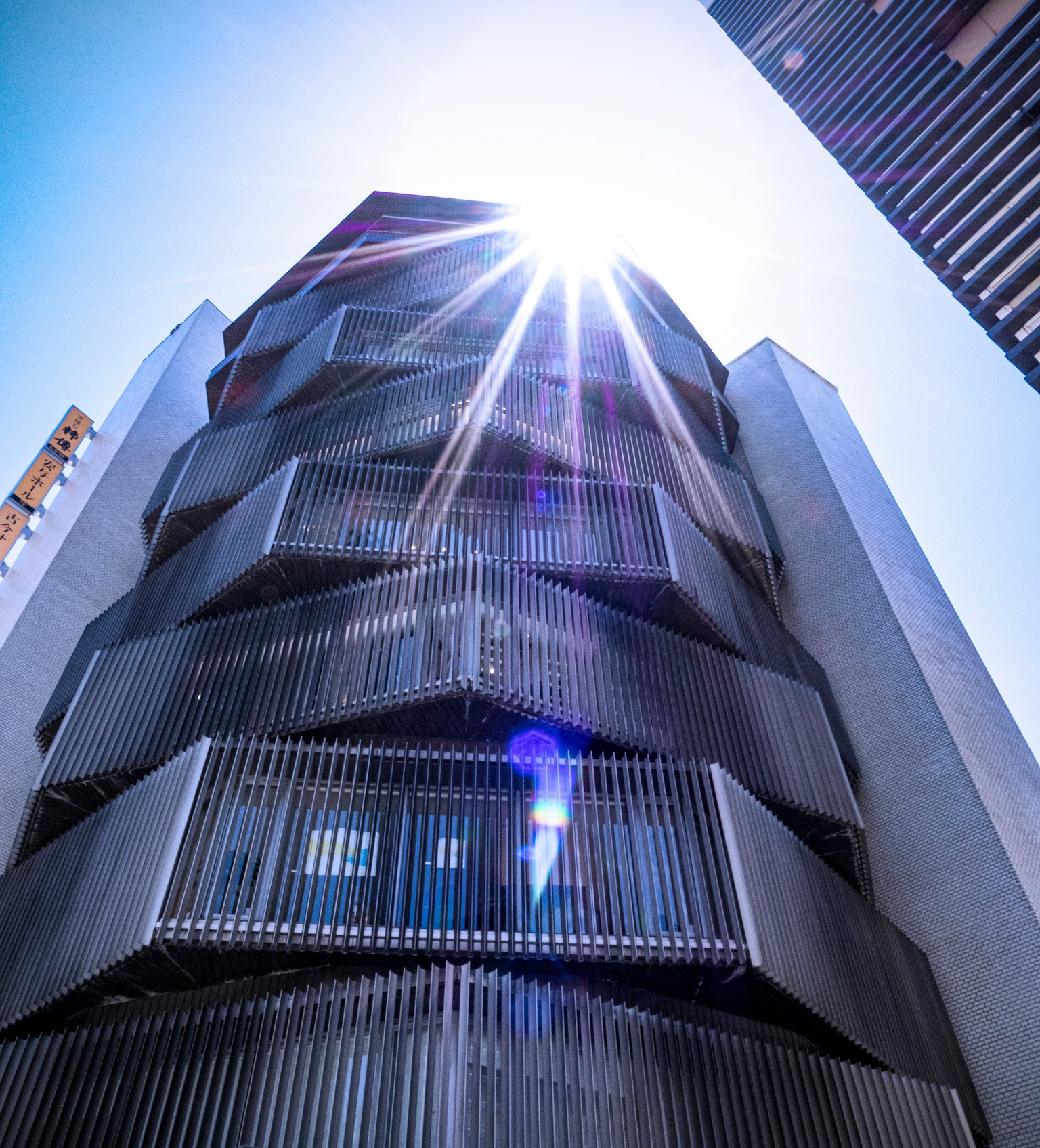 Extérieur d'un bâtiment moderne avec la lumière du soleil se reflétant sur les surfaces