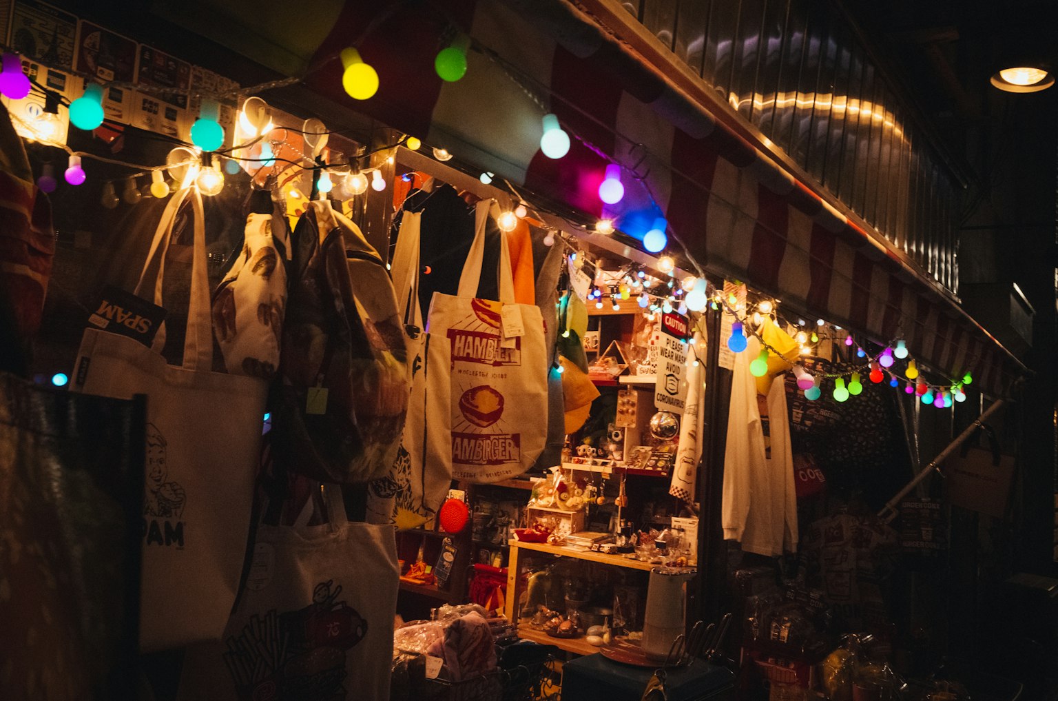 Scène de marché nocturne vibrante avec des lumières colorées et divers articles exposés