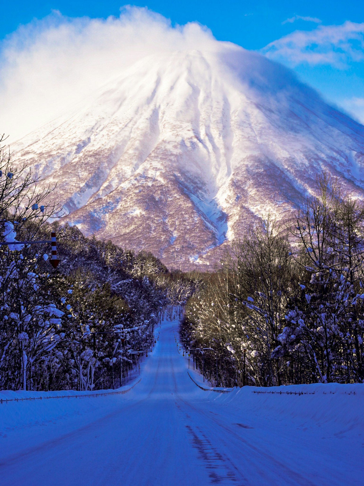 Schneebedeckte Straße, die zu einem majestätischen Berg führt