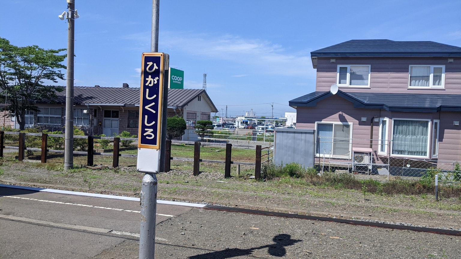 Bus stop sign for Migashikushiro with nearby residential area