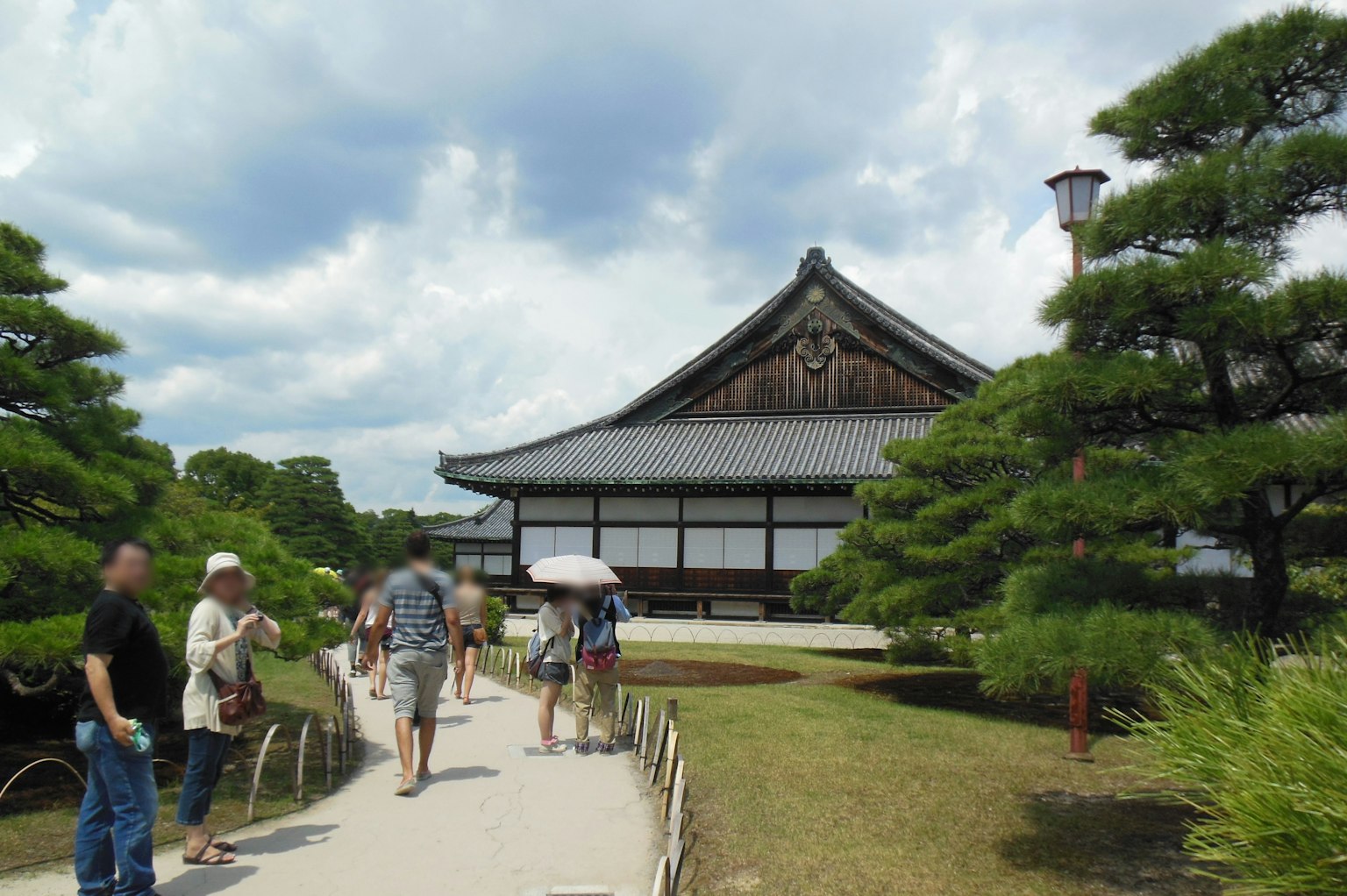 Visitors walking in a beautiful Japanese garden with a traditional building