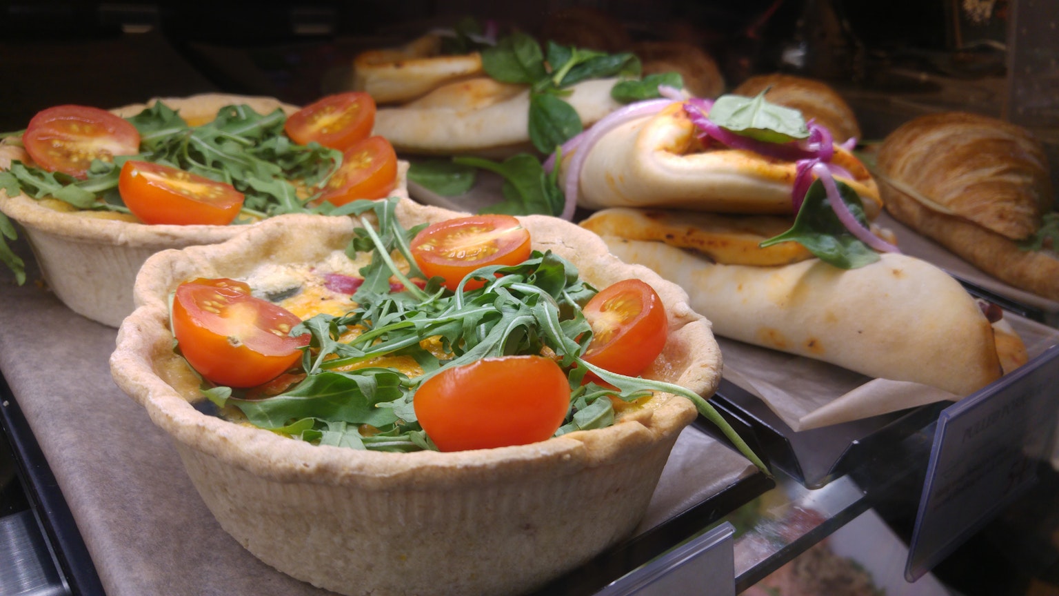 Savory pie topped with colorful tomatoes and arugula