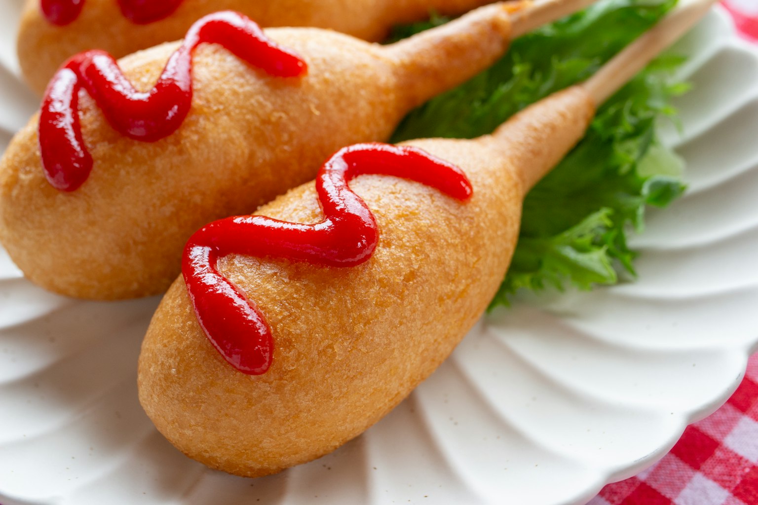 Corn dog fritti con ketchup su un piatto bianco