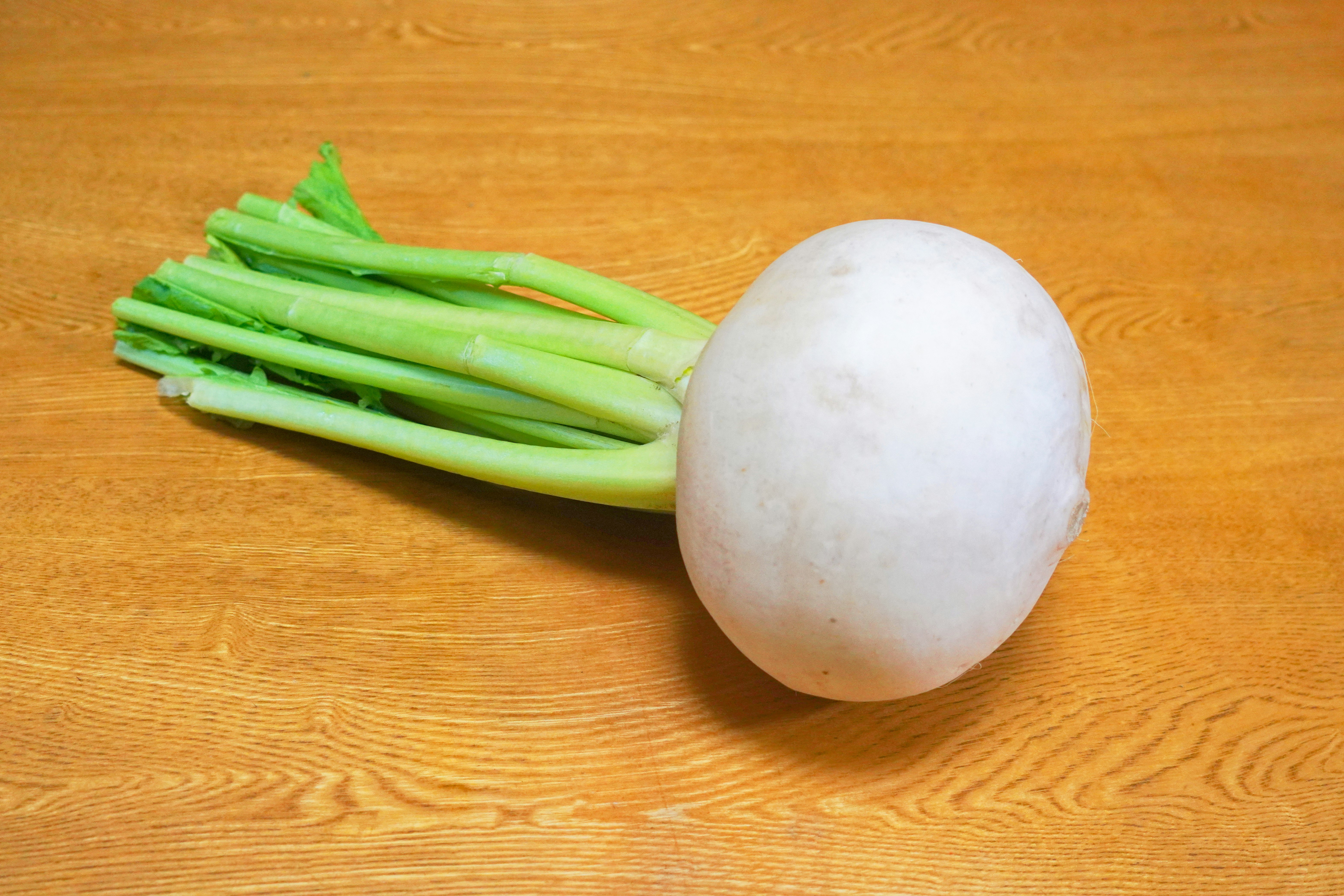 sur une planche à découper, un oignon blanc et des oignons verts