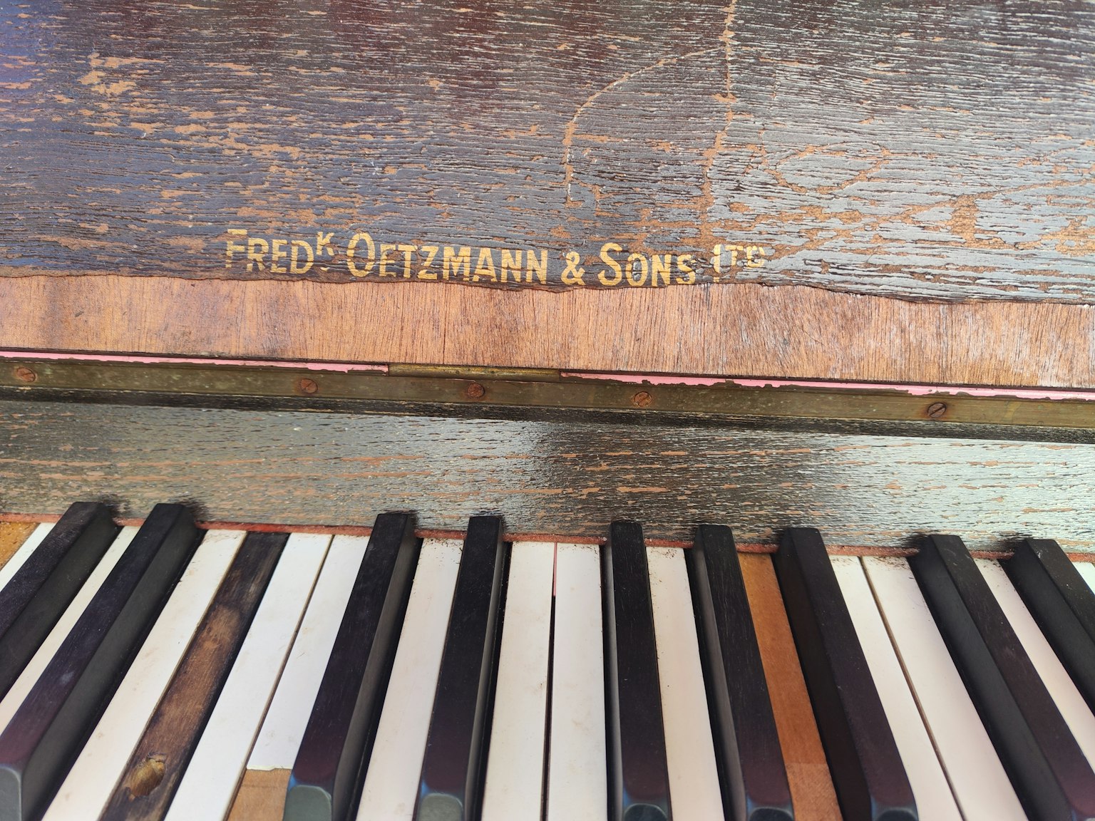 Nahaufnahme einer antiken Klaviatur mit dem Namen Fred Oetzmann & Sons