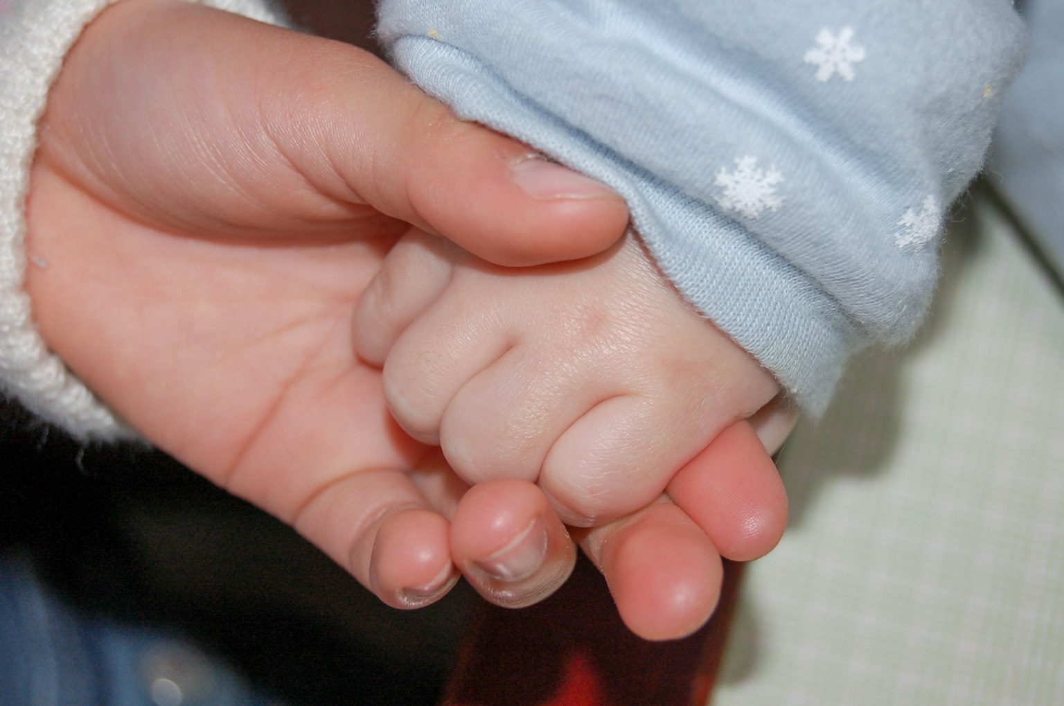 Một khoảnh khắc ấm áp khi tay của người lớn và em bé nắm chặt nhau