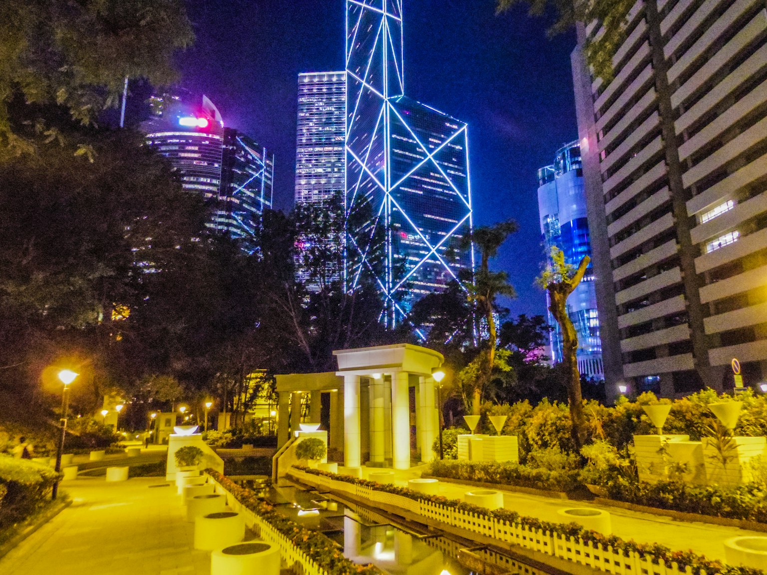 Nachtansicht der Skyline von Hongkong mit beleuchteten Wegen und Wassermerkmalen