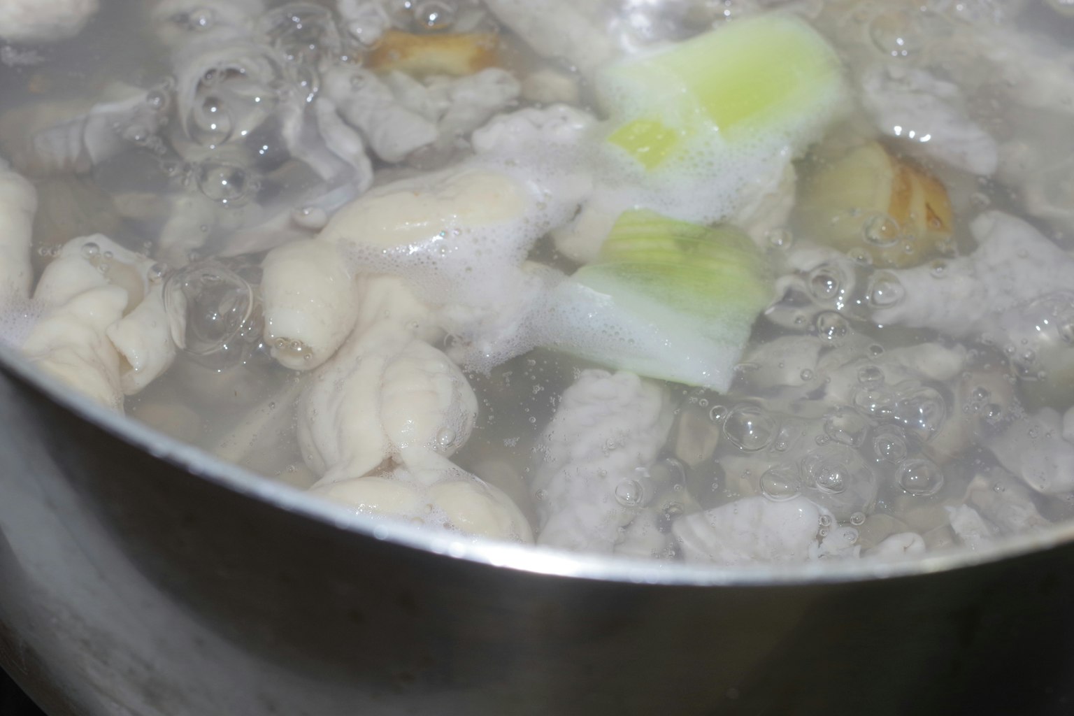 Cooking meat and leeks in a boiling pot