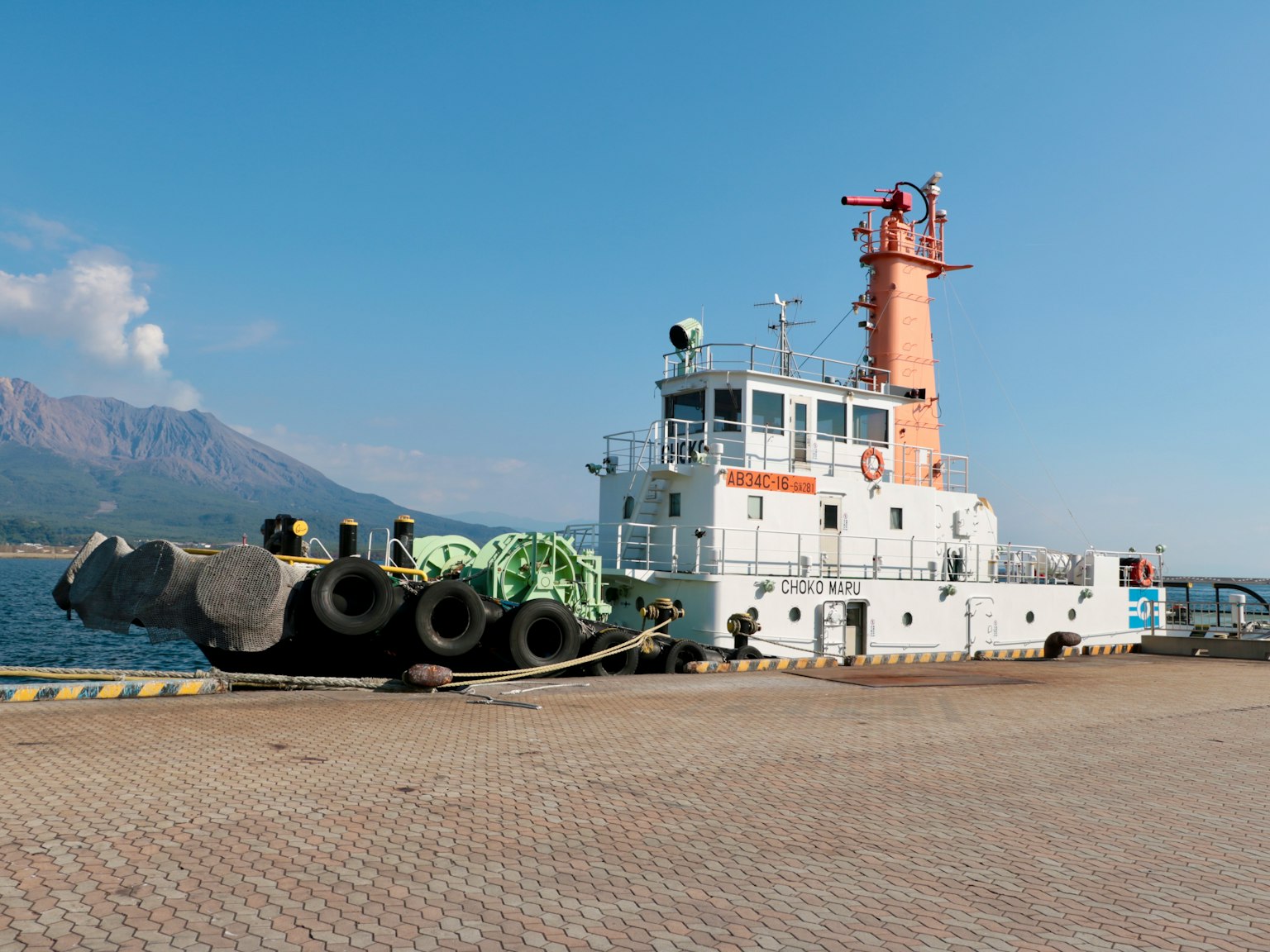 Tugboat docked at the harbor with a clear blue sky