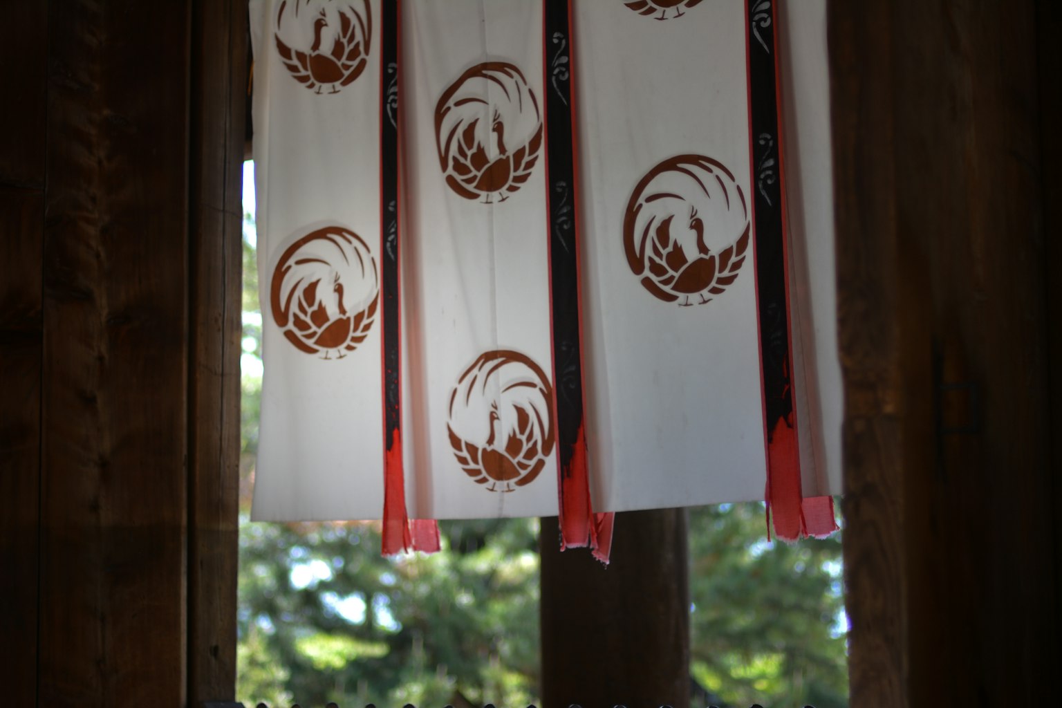 White fabric banners with brown logos hanging in a window