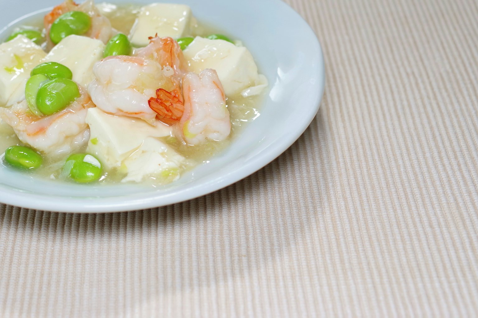 Món tôm và đậu phụ được phục vụ trên đĩa trắng