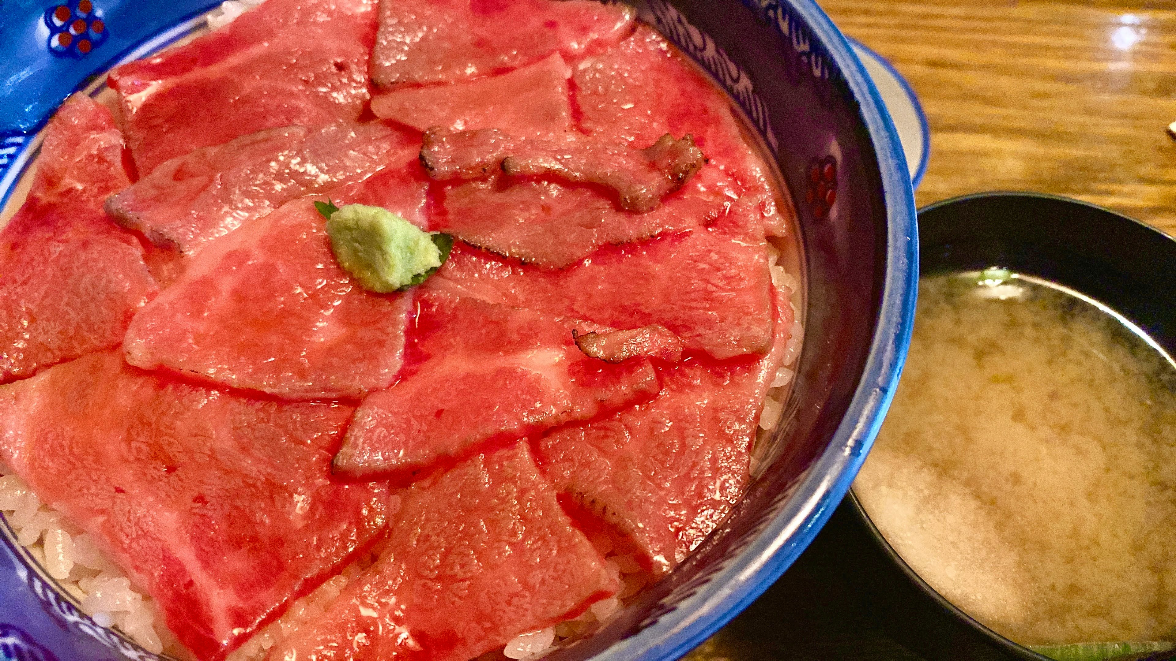 Bowl of red watermelon flesh with seeds beside a white bowl