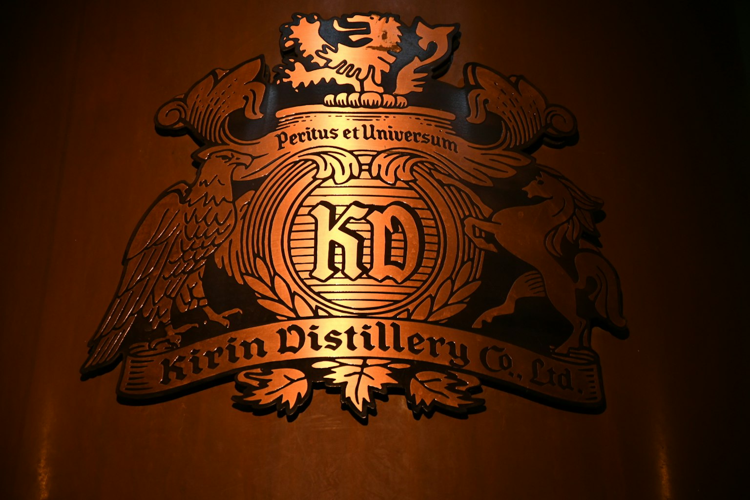 Kirin-Destillerielogo in erhabenem Gold auf dunklem Hintergrund