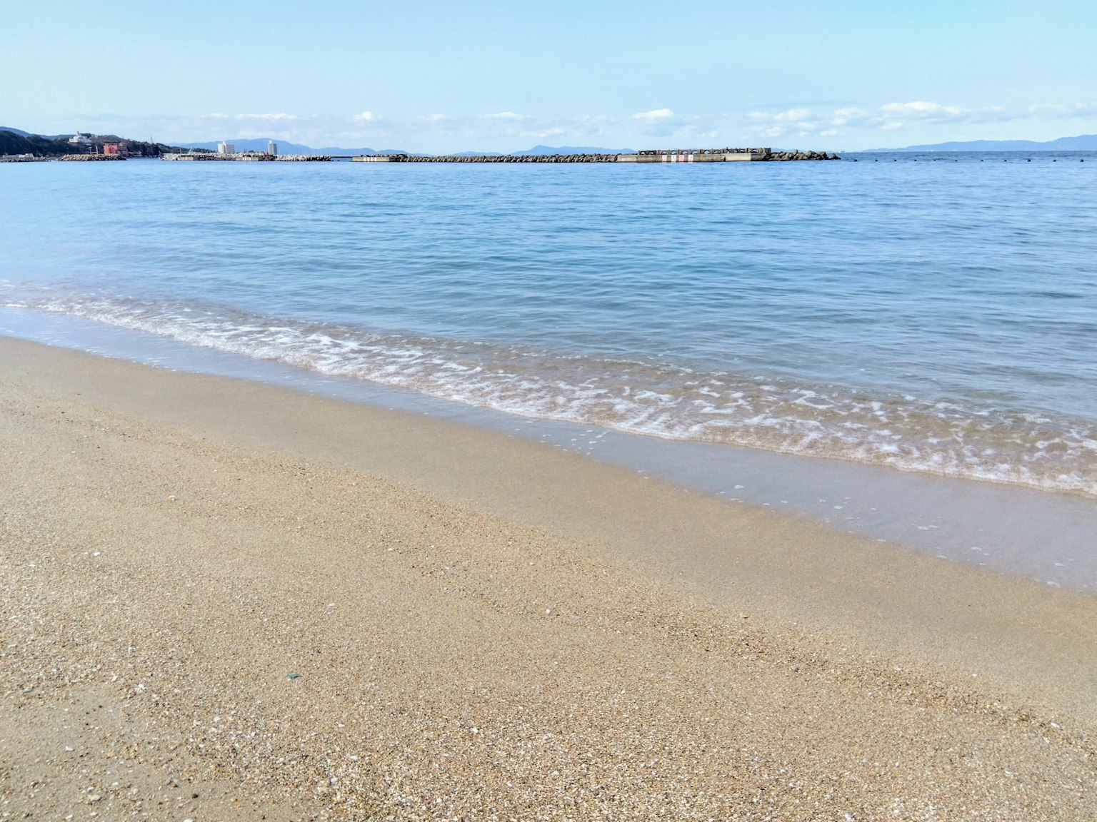 Scène de plage calme avec des vagues douces et un ciel bleu