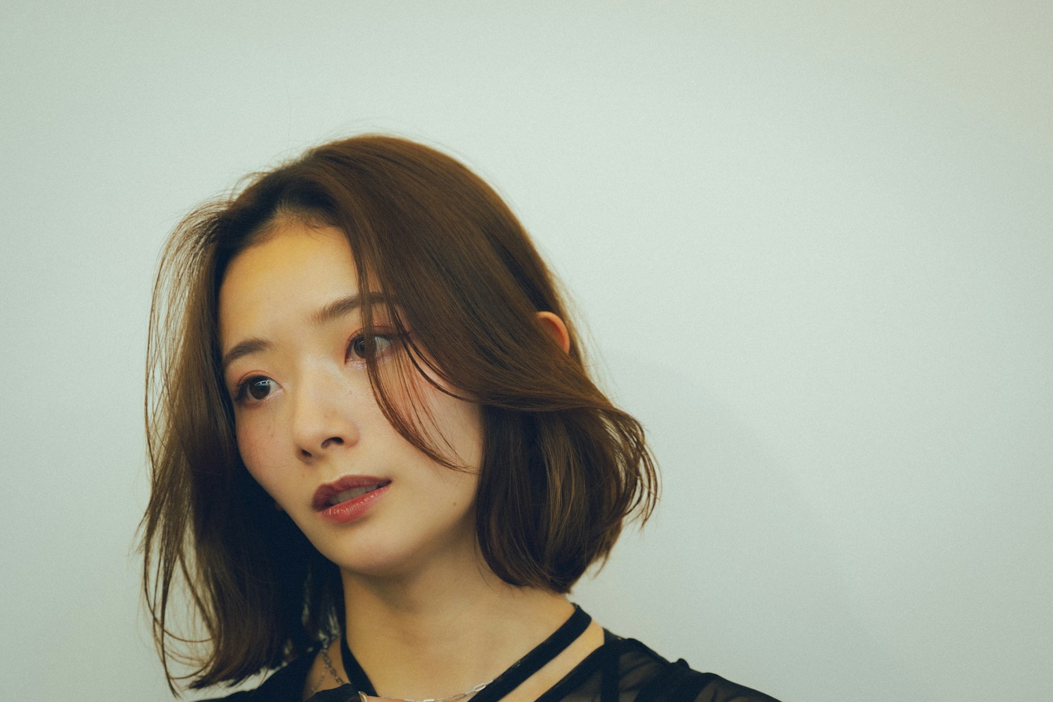 ภาพถ่ายบุคคลของหญิงสาวที่มีผมยาวถึงไหล่สวมชุดสีดำ