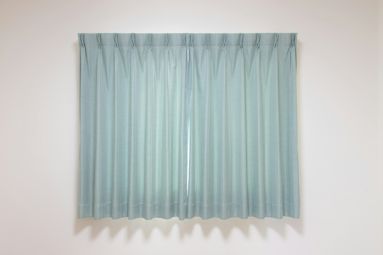 Cortinas azul claro cubriendo una ventana con un diseño simple
