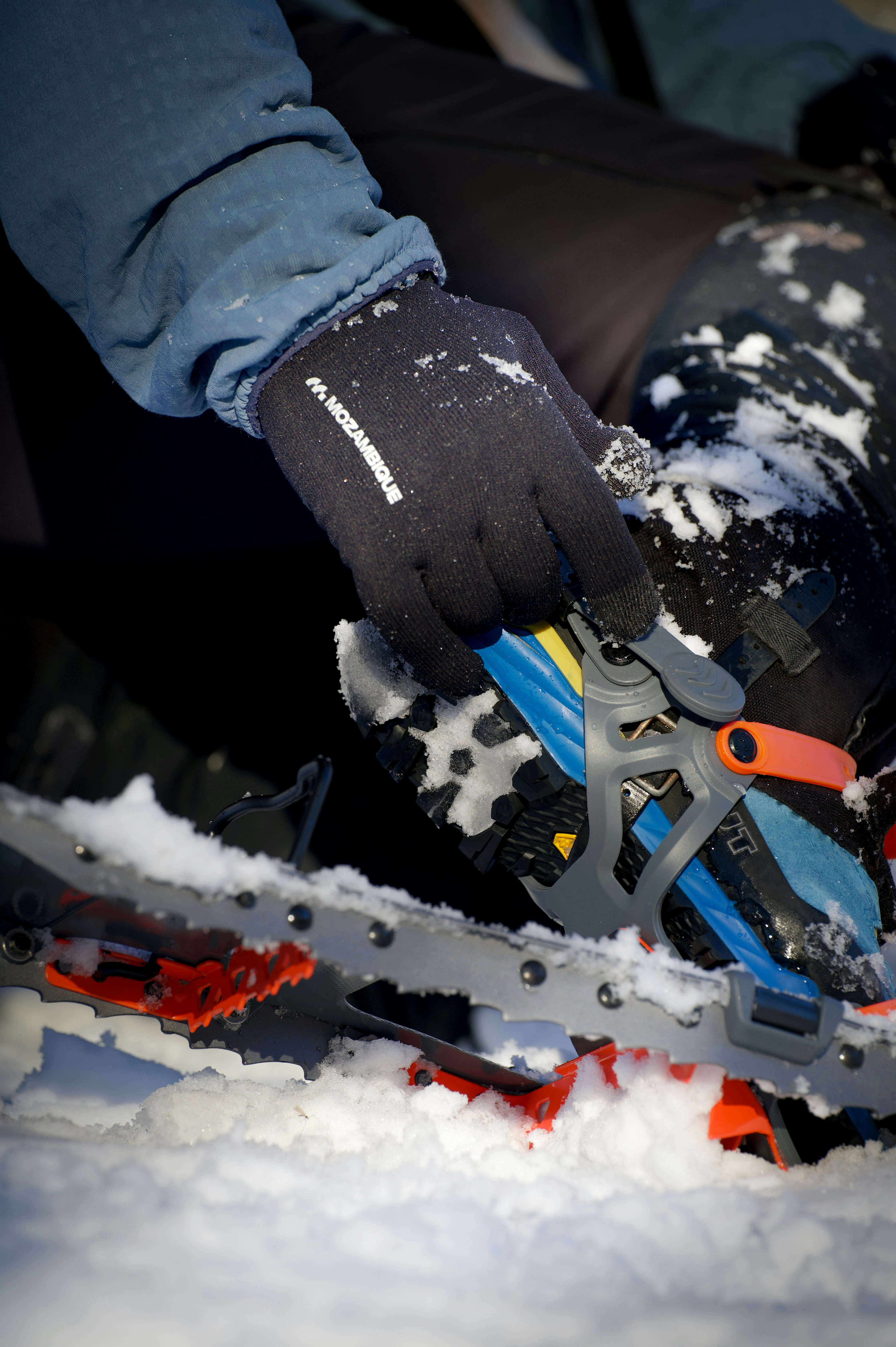 manos con guantes manipulando herramientas de nieve sobre la nieve