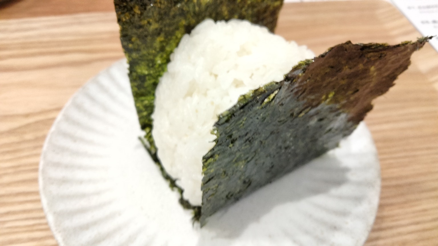 三角形米飯包裹海苔放在盤子上