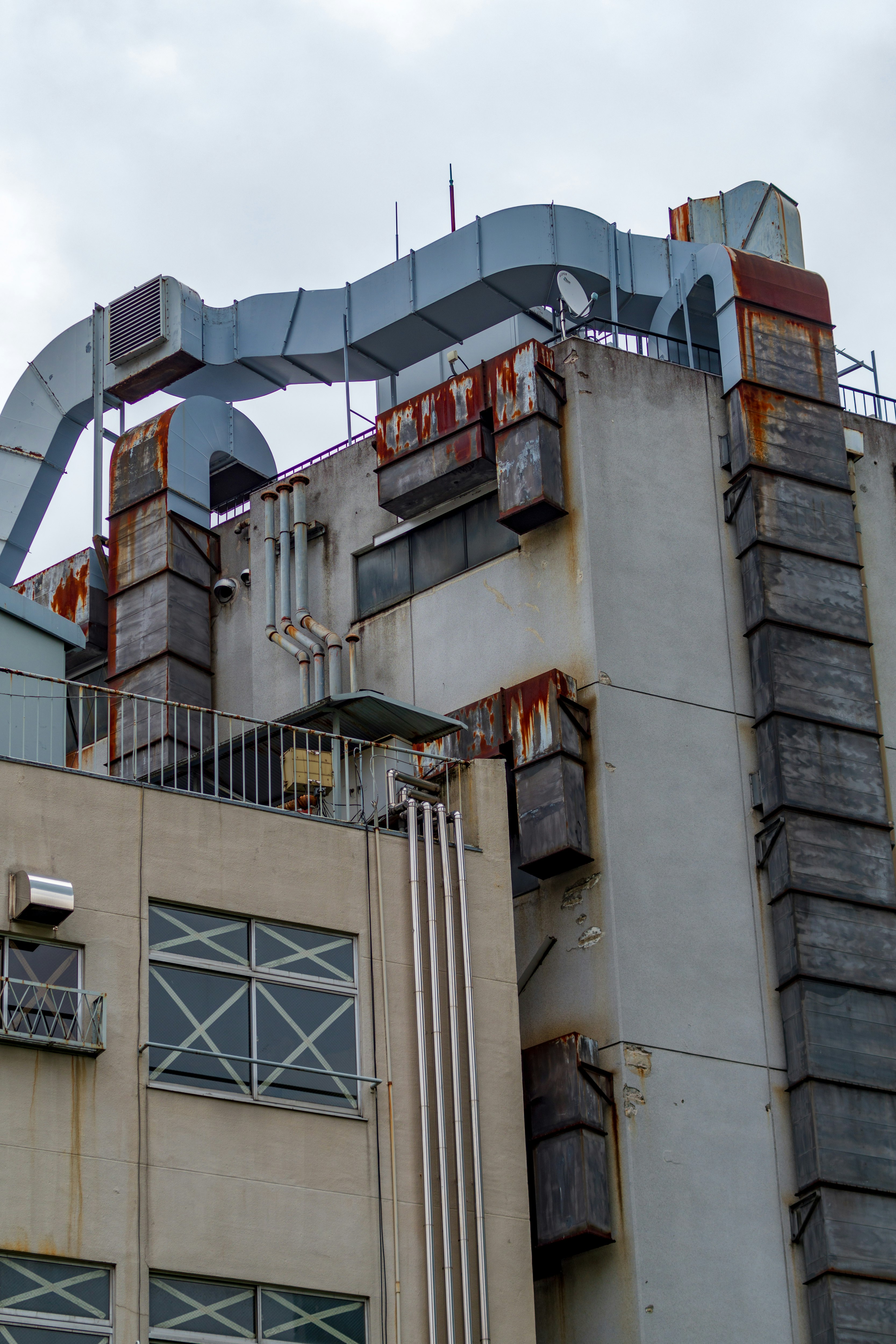 Exterior of an industrial facility with smokestacks and ventilation ducts