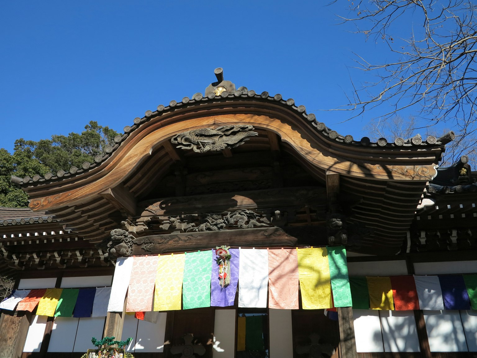 Traditional temple gate with ornate roof colorful prayer flags hanging
