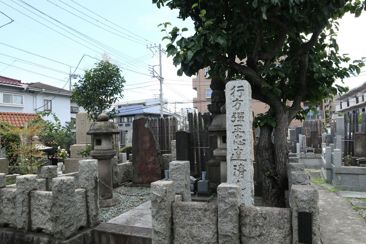 Vue pittoresque d'un cimetière avec un monument en pierre et un arbre
