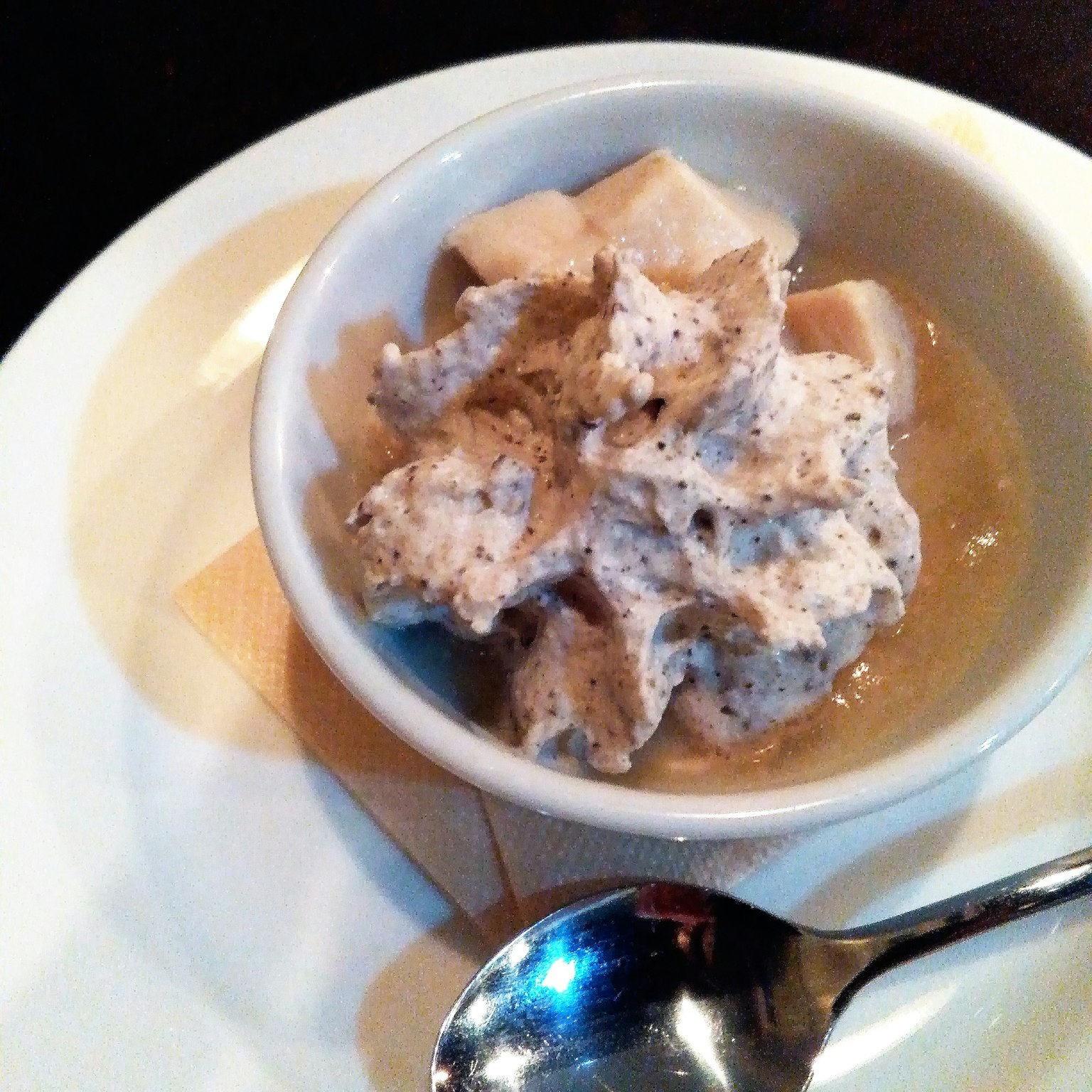 Bowl di dessert con crema e pezzi di banana coperti da una salsa