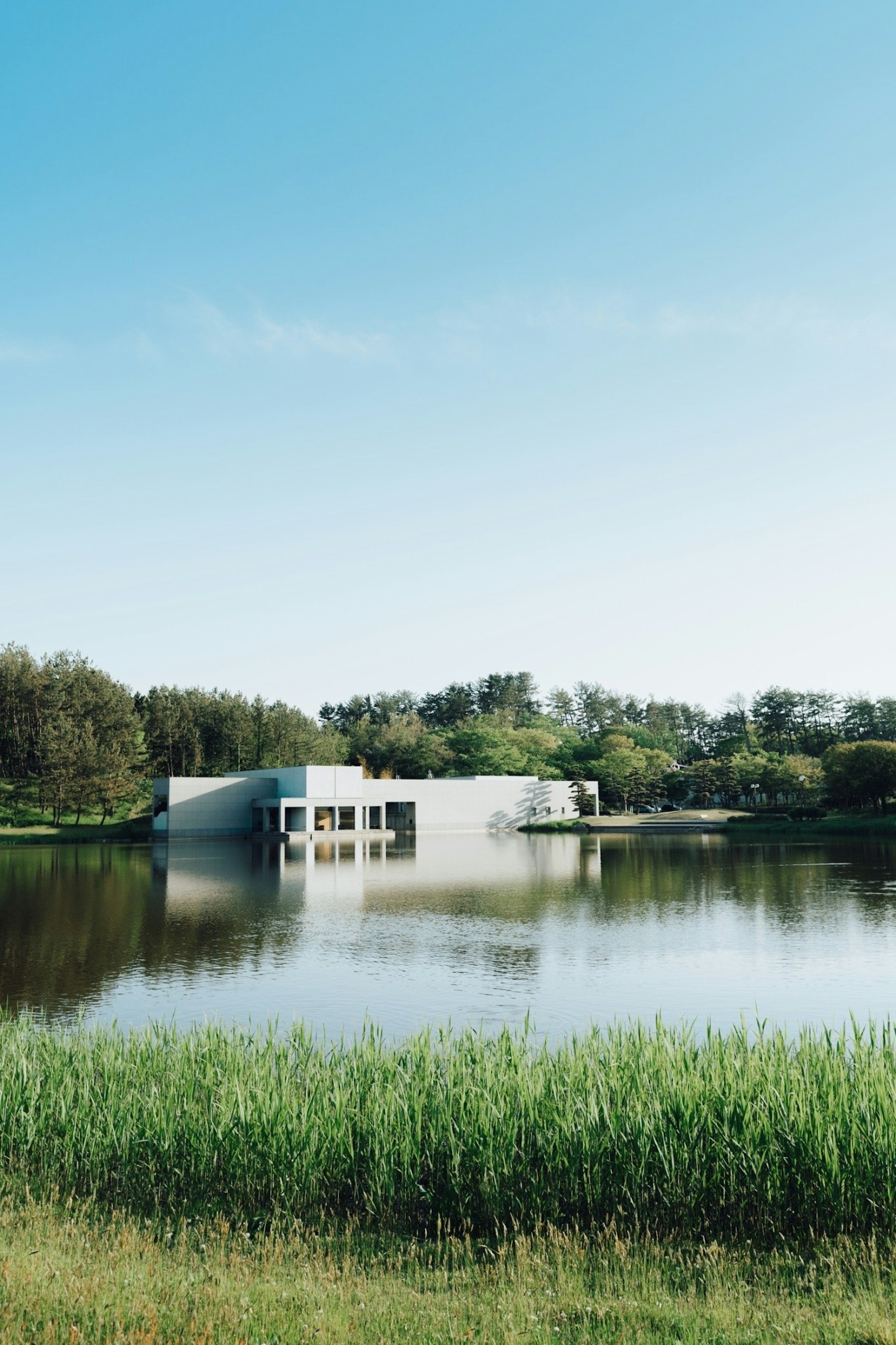 Bâtiment moderne blanc au bord de l'eau sous un ciel bleu