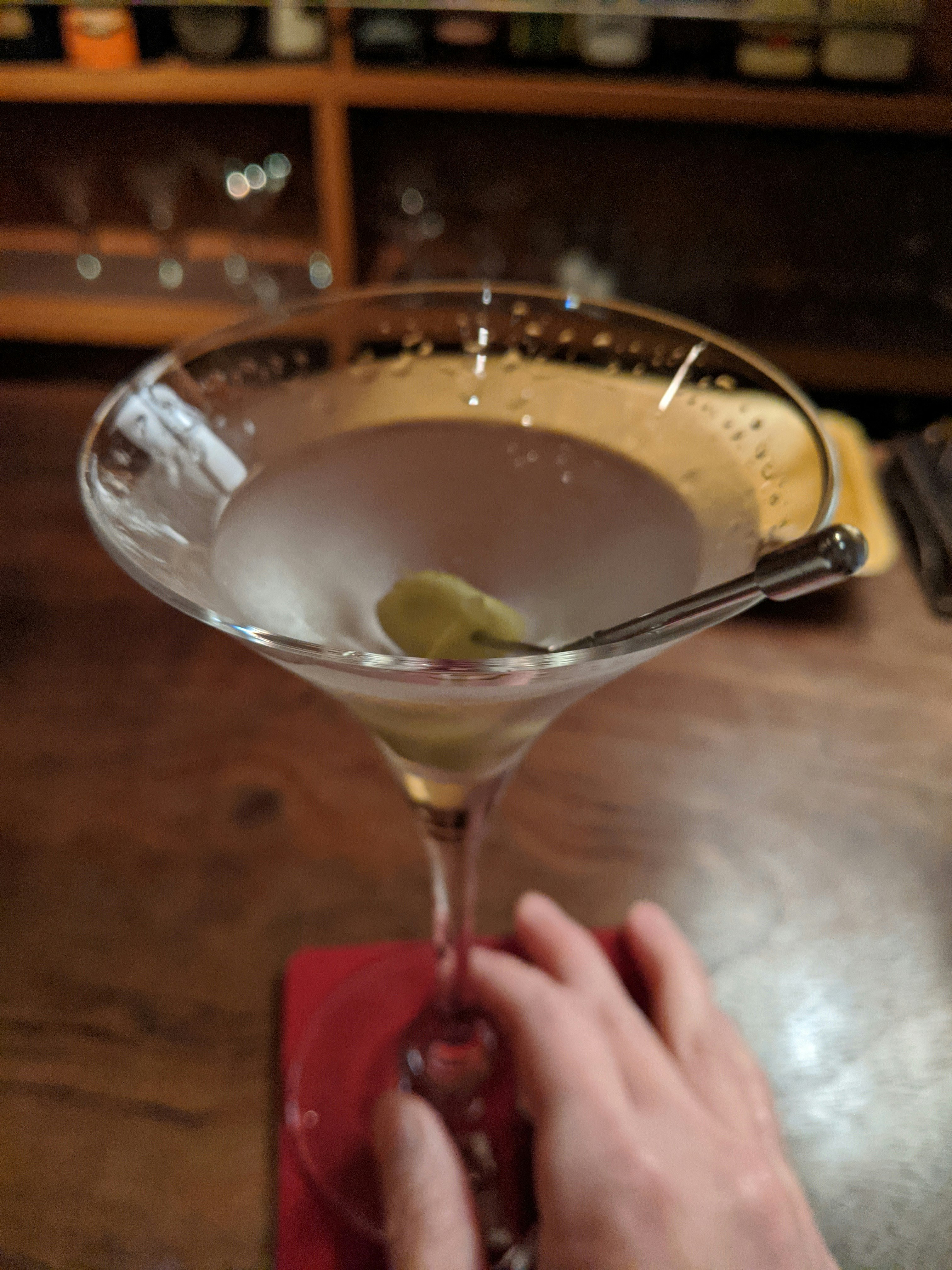 手將雞尾酒倒入酒杯