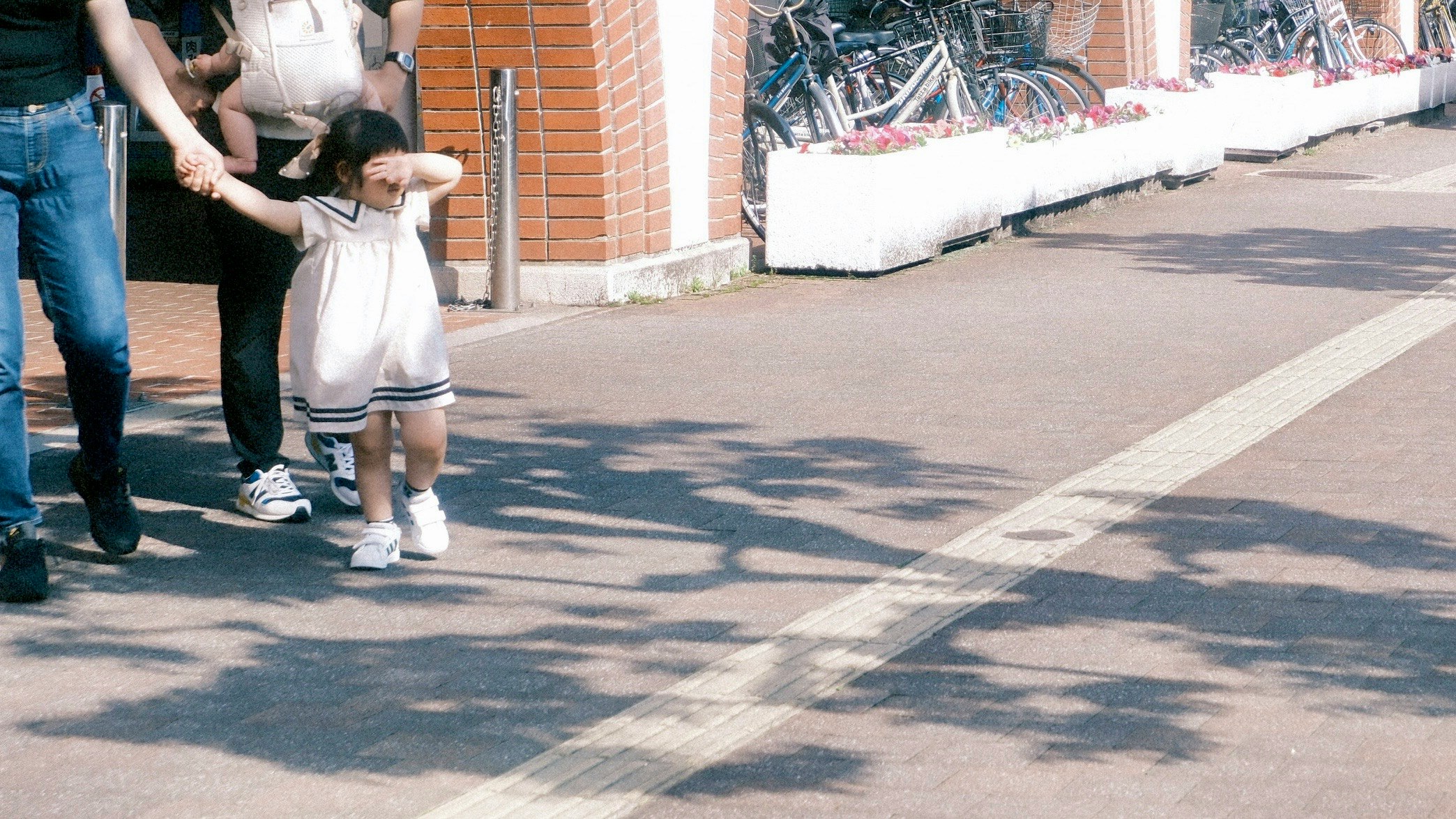 レンガ壁の路地で手をつなぐ親子の散歩
