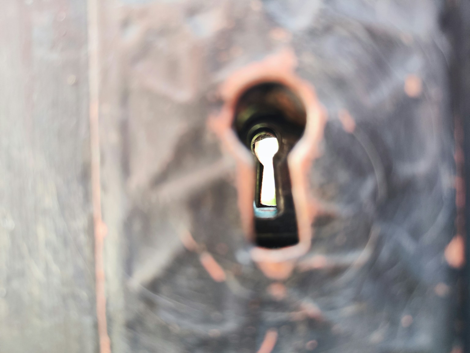 Close-up of a keyhole on an old wooden door