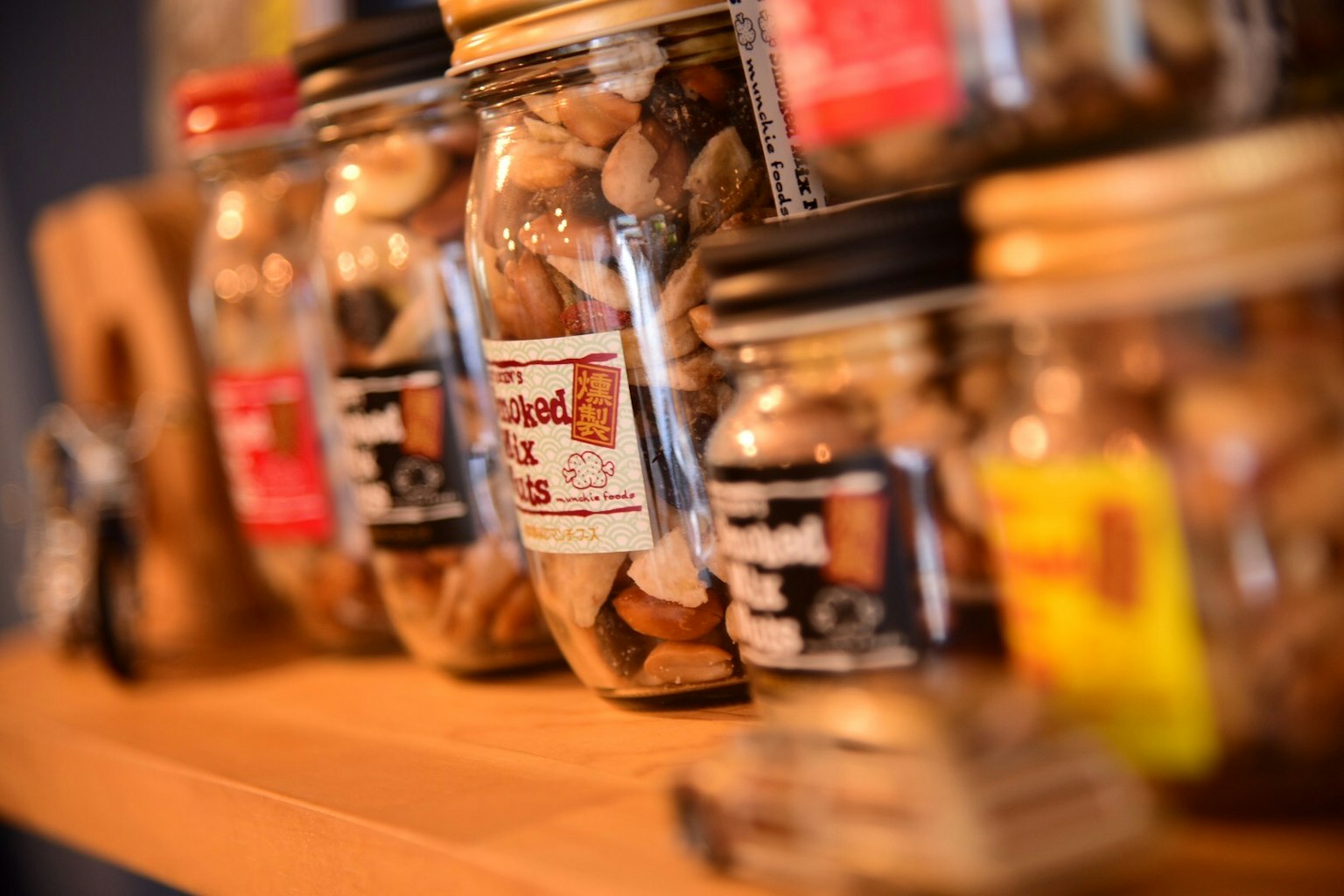 Berbagai toples berisi kacang dipajang di rak kayu