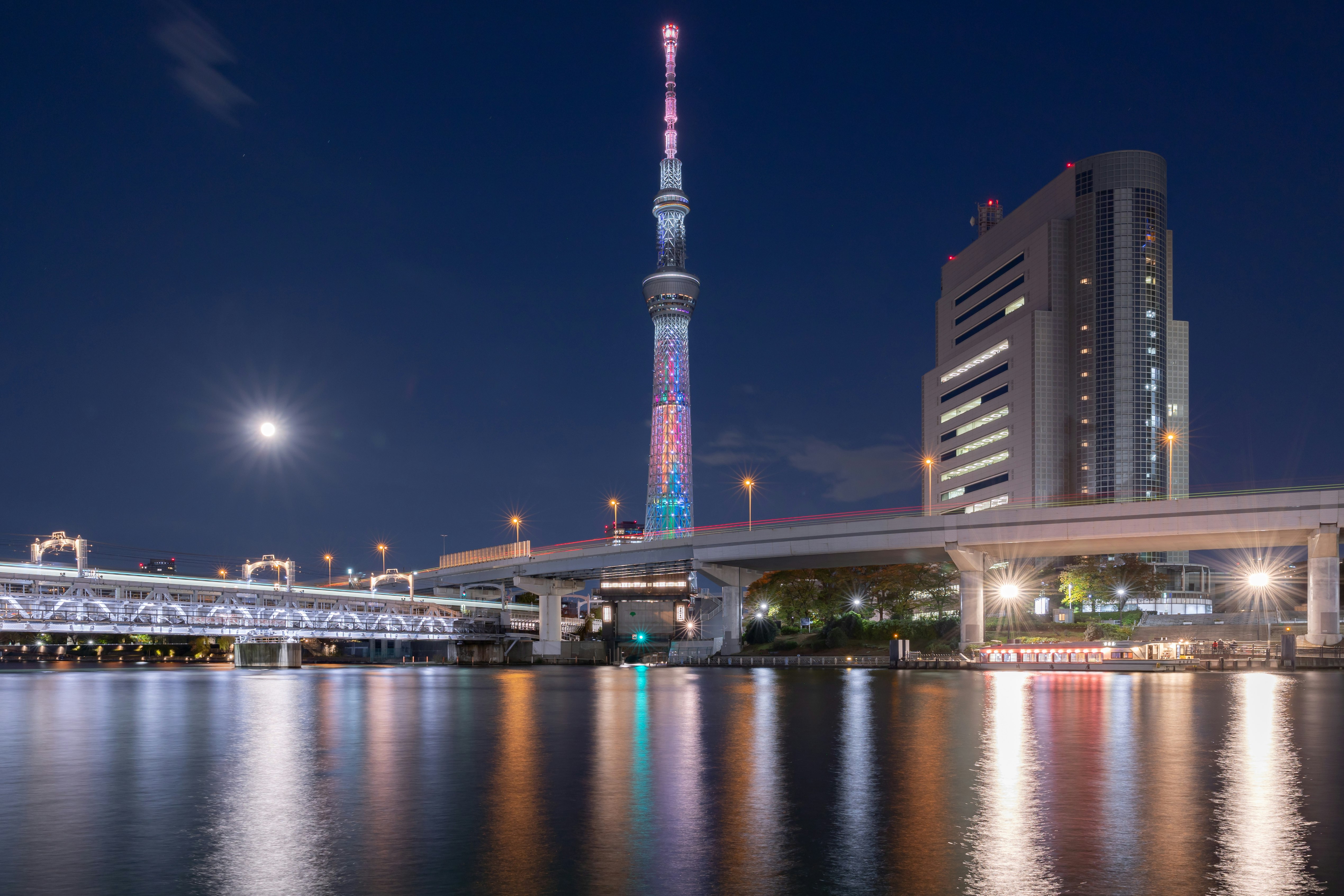 夜の川沿いに映える東京スカイツリーと橋の夜景