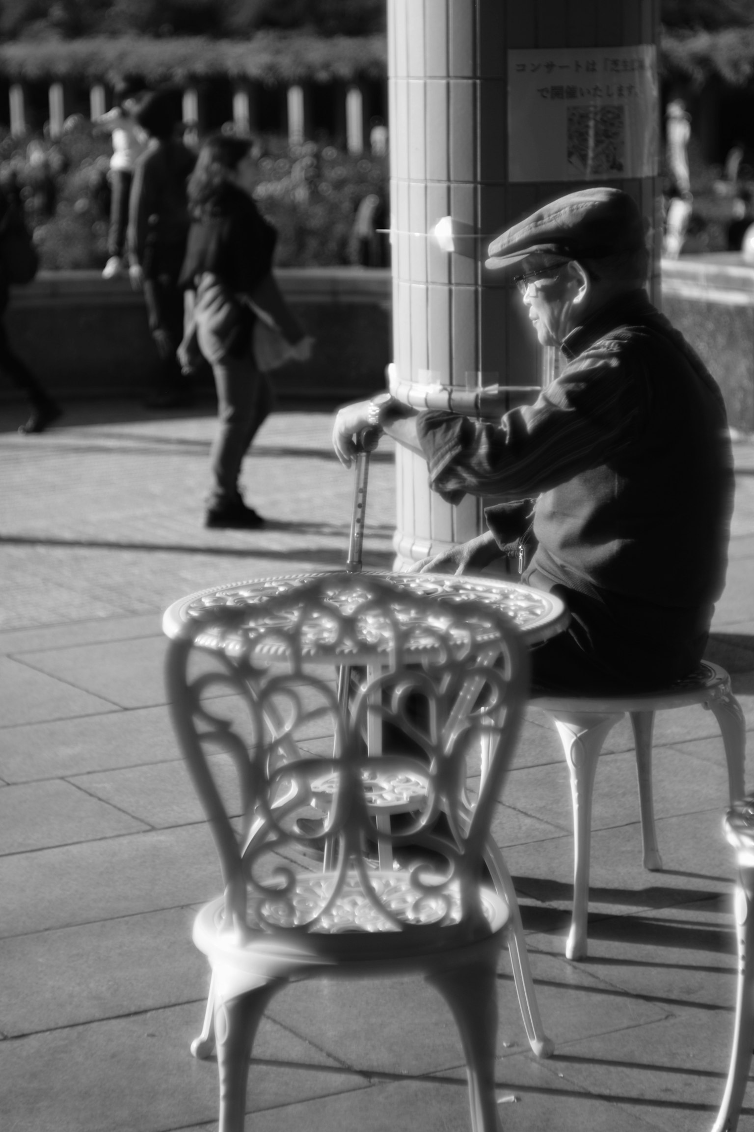 Una foto en blanco y negro de un anciano tocando la flauta sentado en un banco del parque