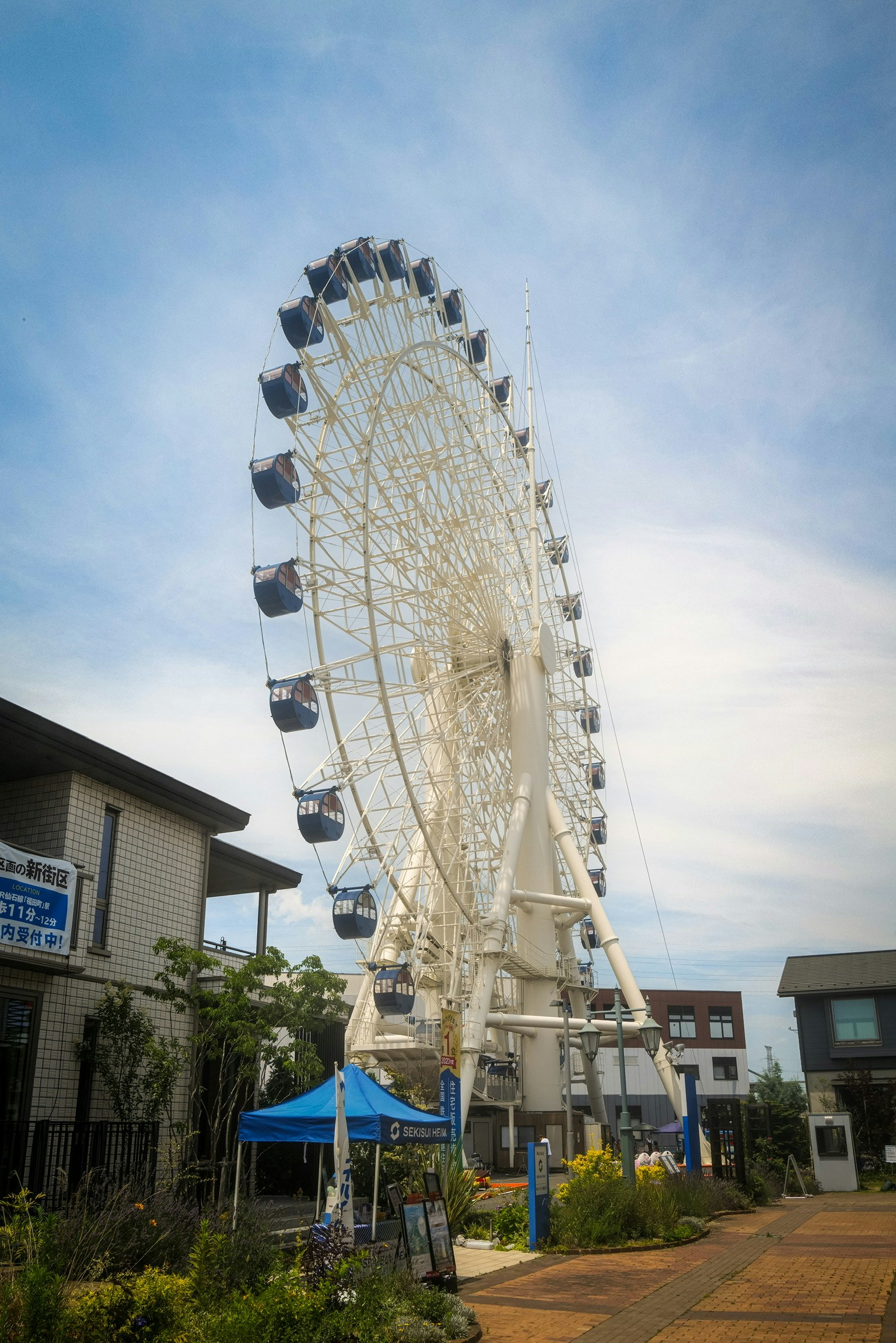 観覧車がそびえる住宅展示場の屋外通路