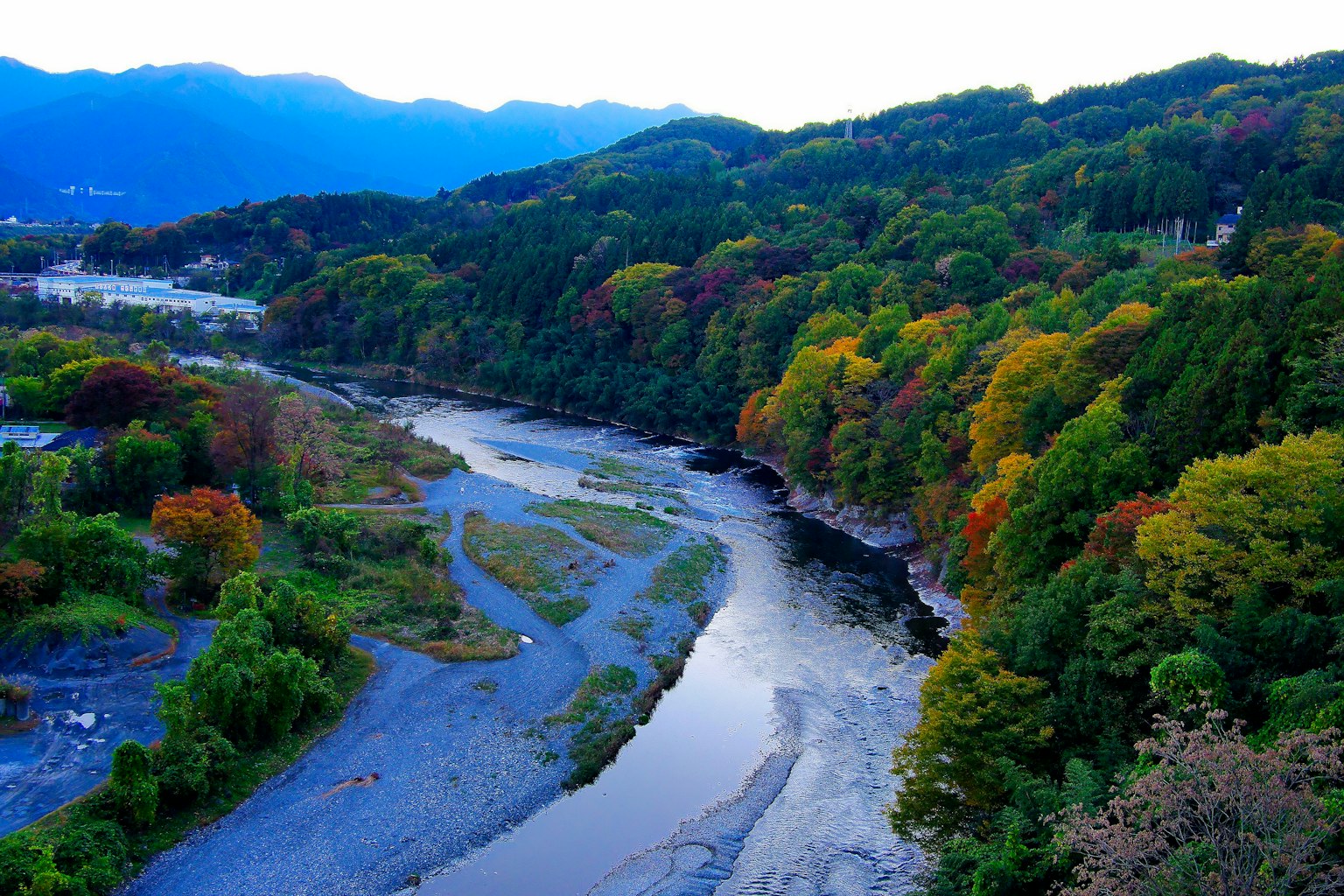 ทิวทัศน์ที่สวยงามของแม่น้ำที่คดเคี้ยวผ่านใบไม้ฤดูใบไม้ร่วงที่มีสีสัน