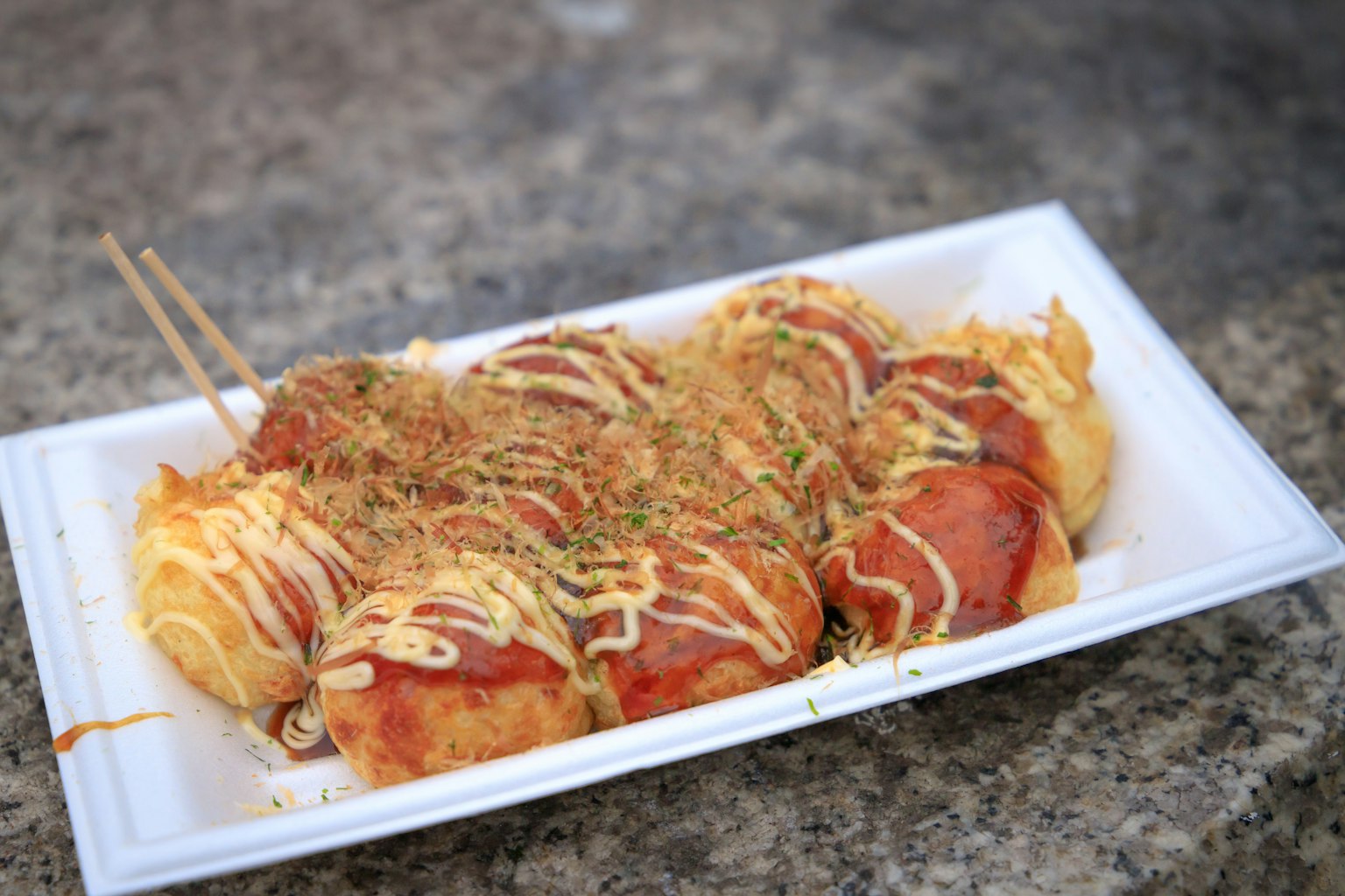 Délicieuse portion de takoyaki arrosée de mayonnaise et garnie d'aonori