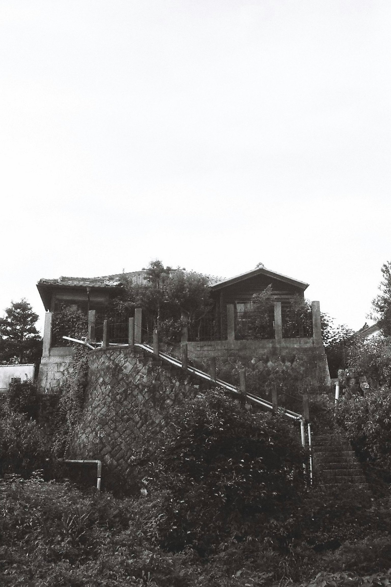 ภาพขาวดำของบ้านที่มีบันไดขึ้นไป