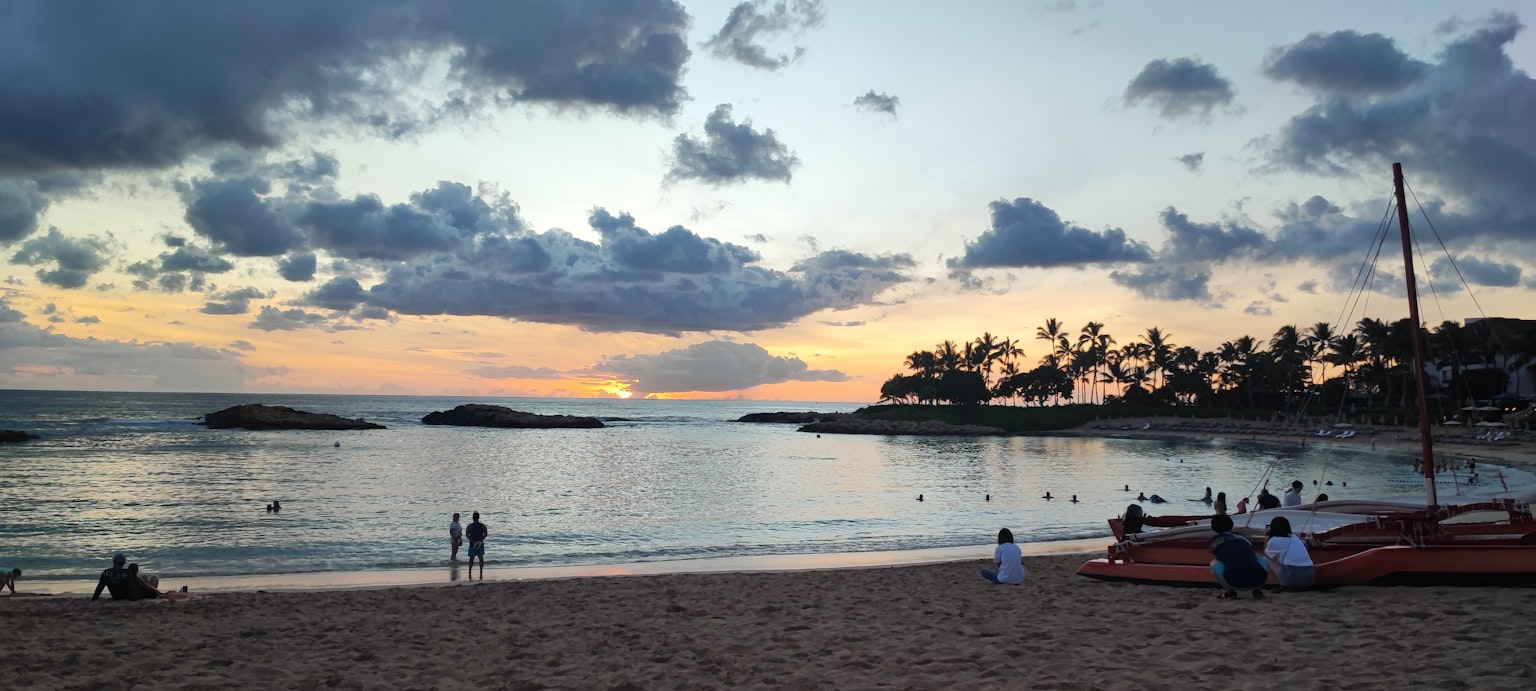 Bella scena di tramonto sulla spiaggia con persone che si rilassano sulla sabbia