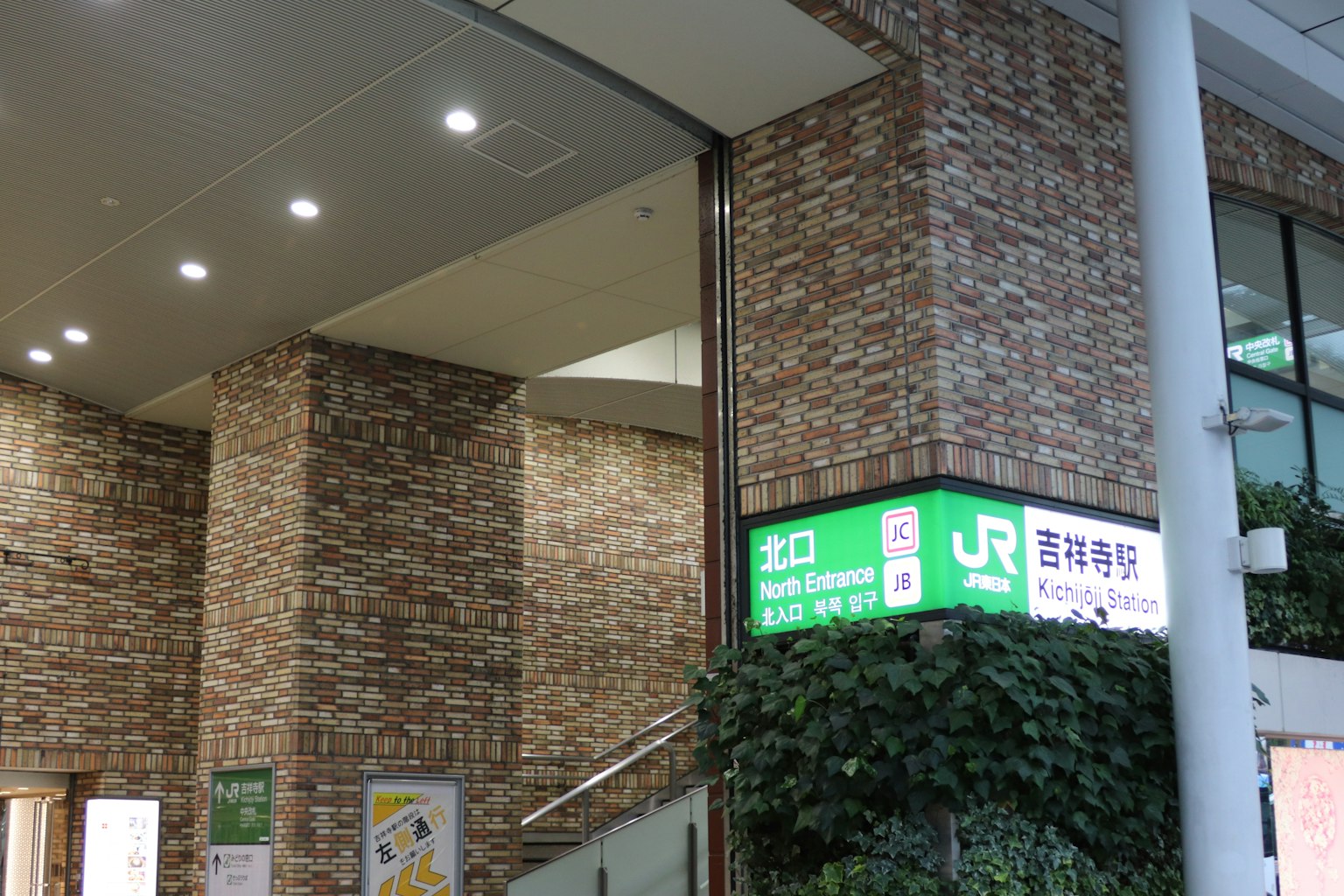 Entrada de una estación de tren con un letrero JR verde