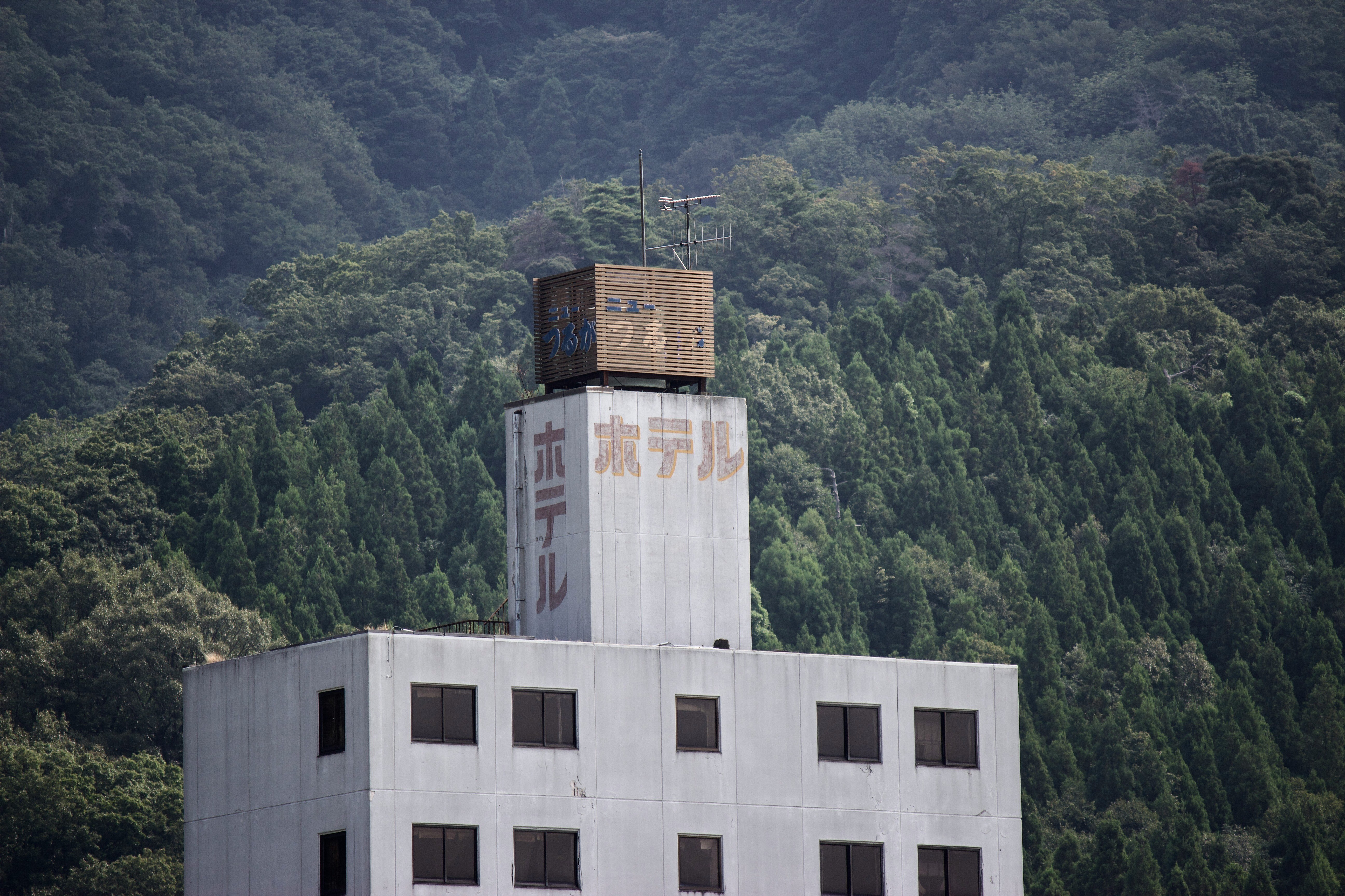 factory smokestack and sign against a mountainside