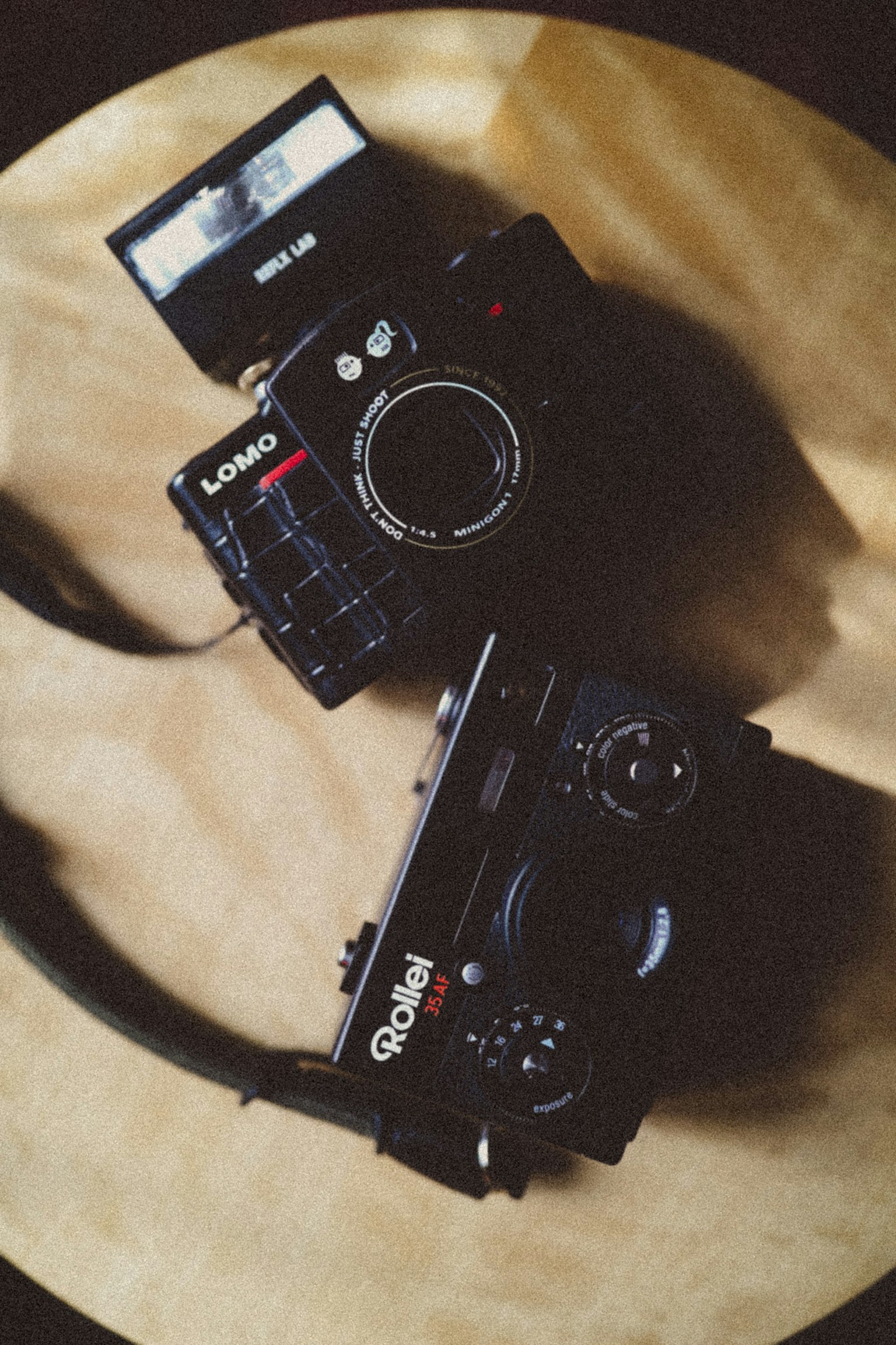 Two cameras placed on a wooden table