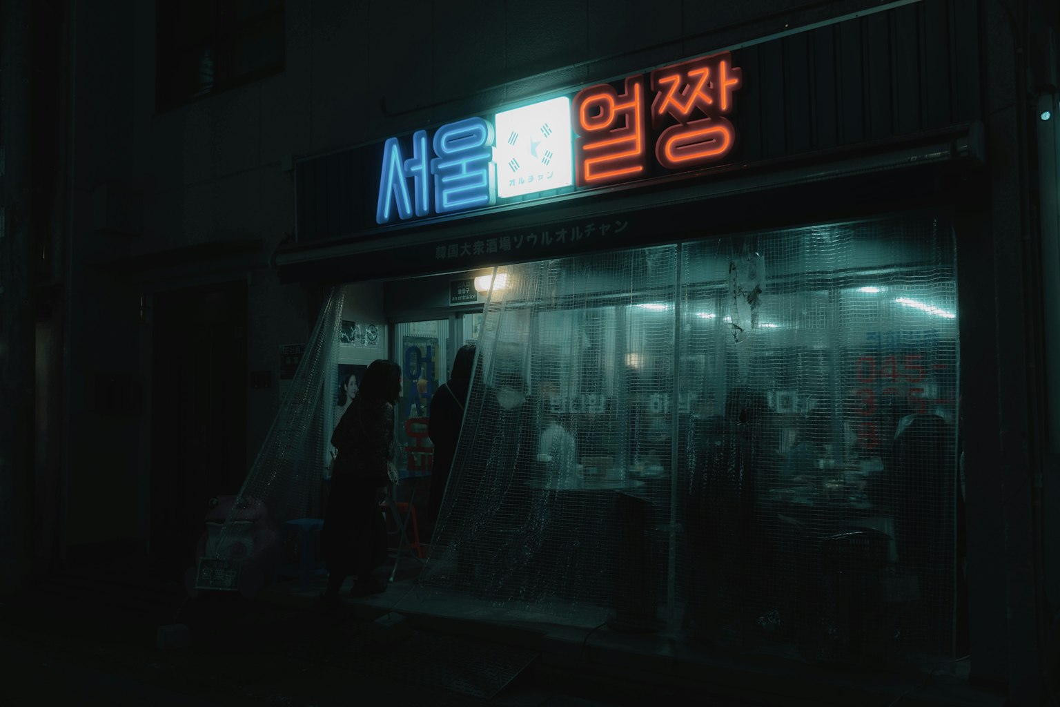 Tampak depan toko di Seoul yang diterangi oleh lampu neon di malam hari