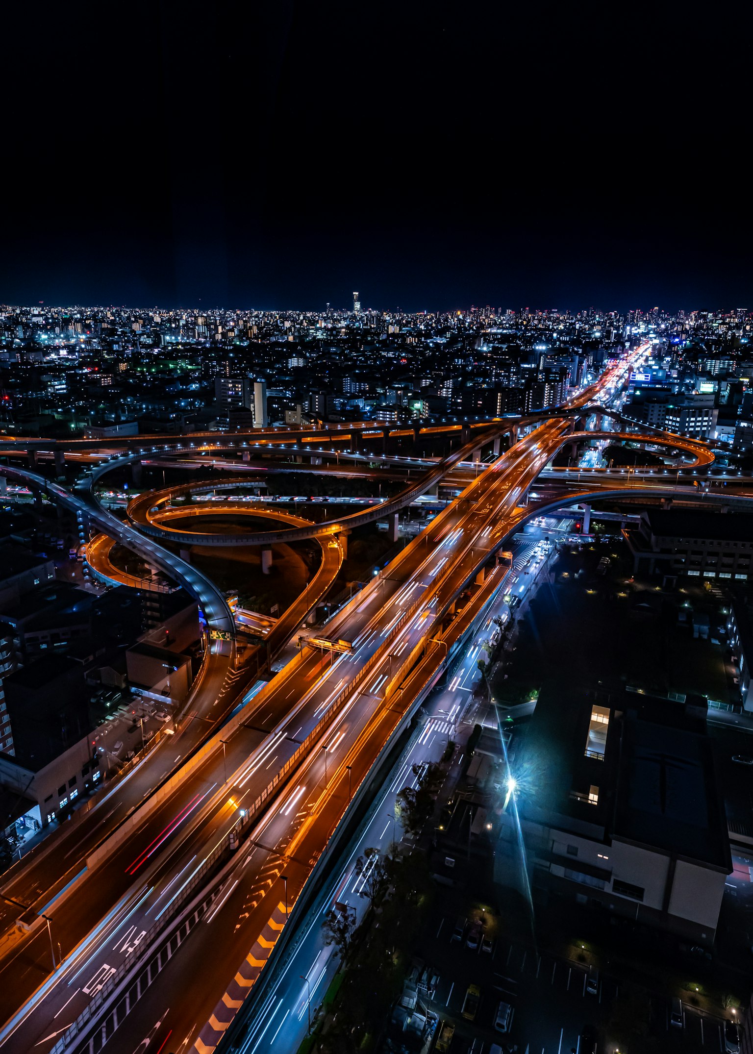 Vista aérea de una ciudad de noche con carreteras complejas y luces brillantes
