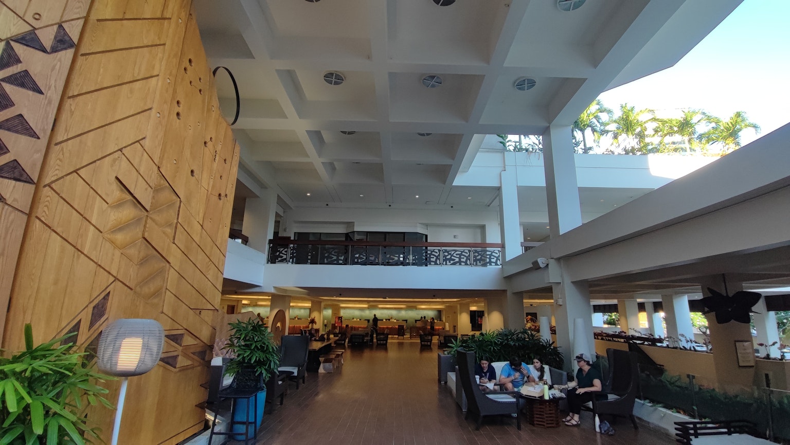 Lobby spazioso di un resort con decorazioni in legno e piante