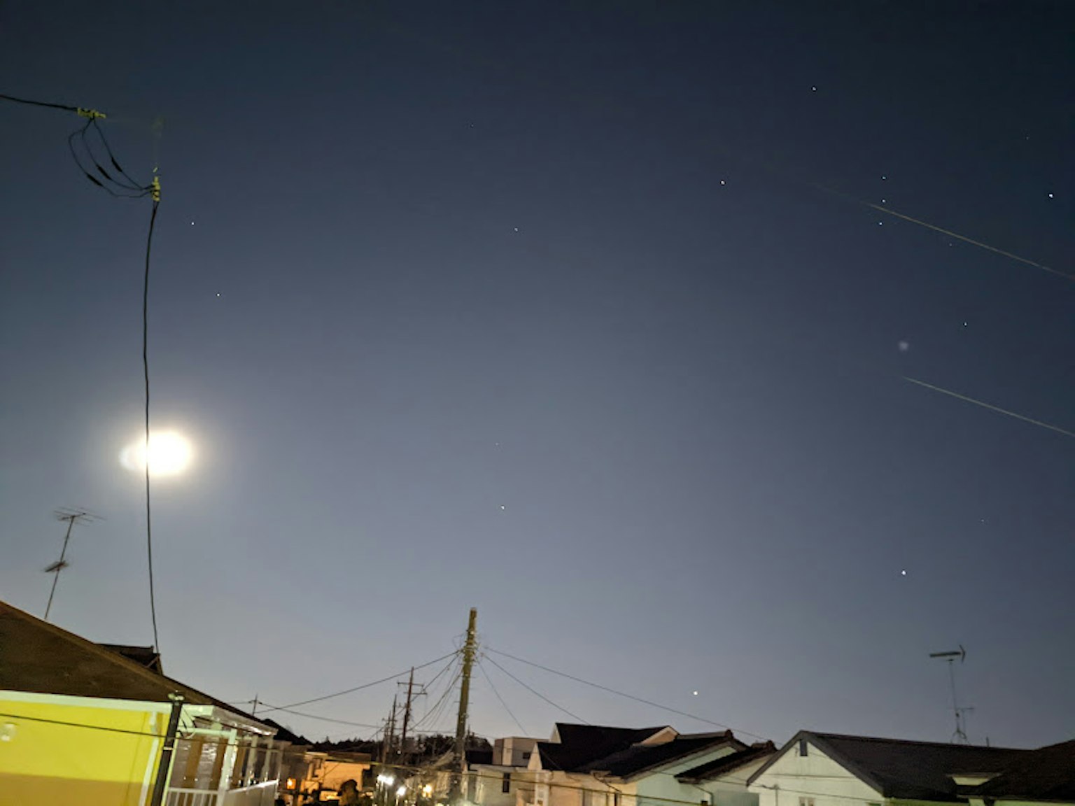 Pemandangan malam dengan bulan dan bintang lampu daerah pemukiman
