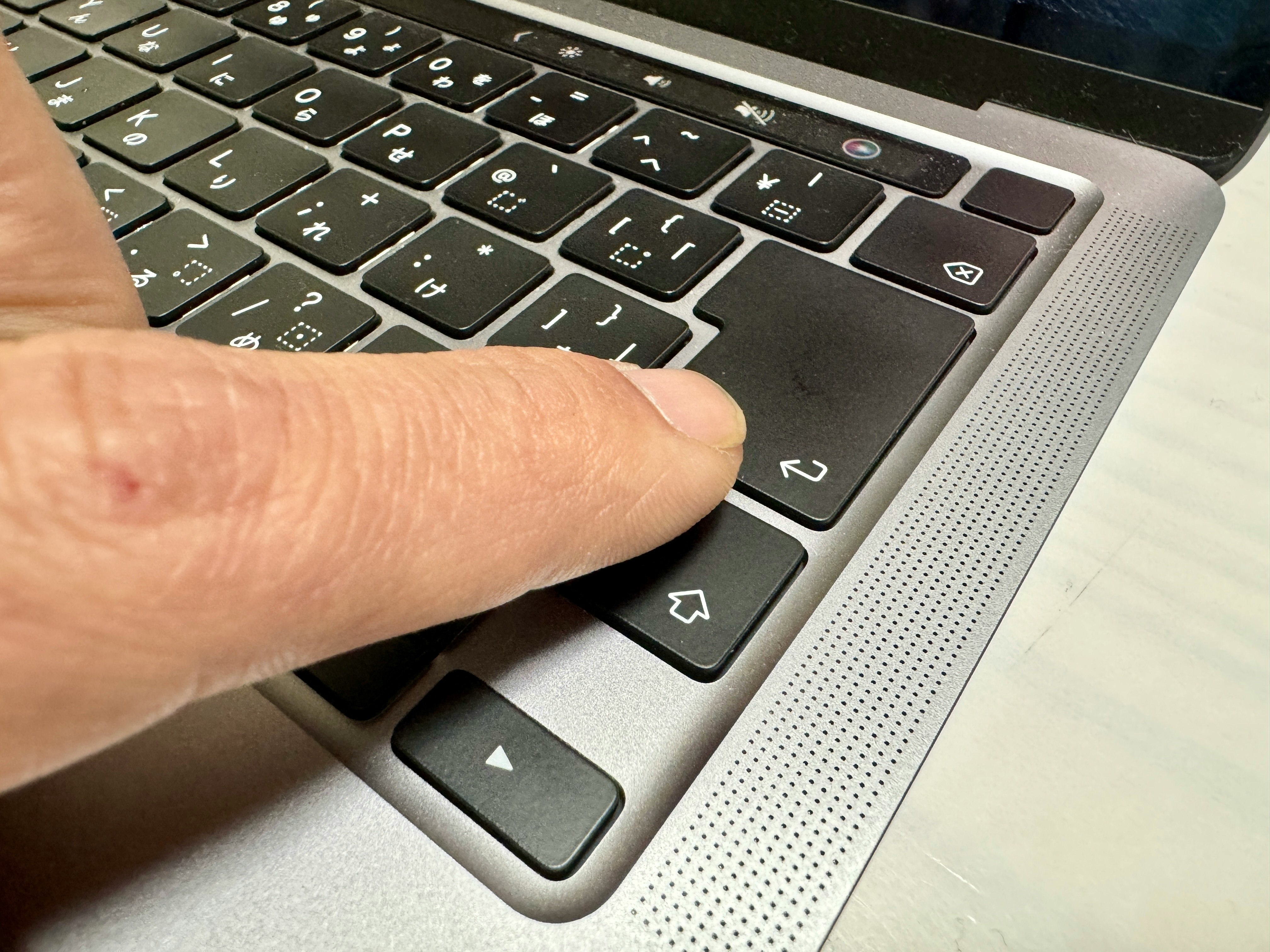 ノートPCのキーボードに触れる手元