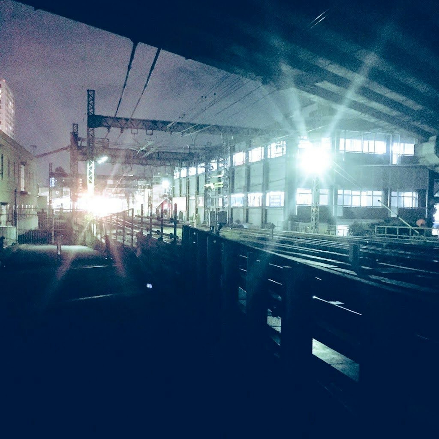 Interior pabrik di malam hari lampu terang dan rel kereta