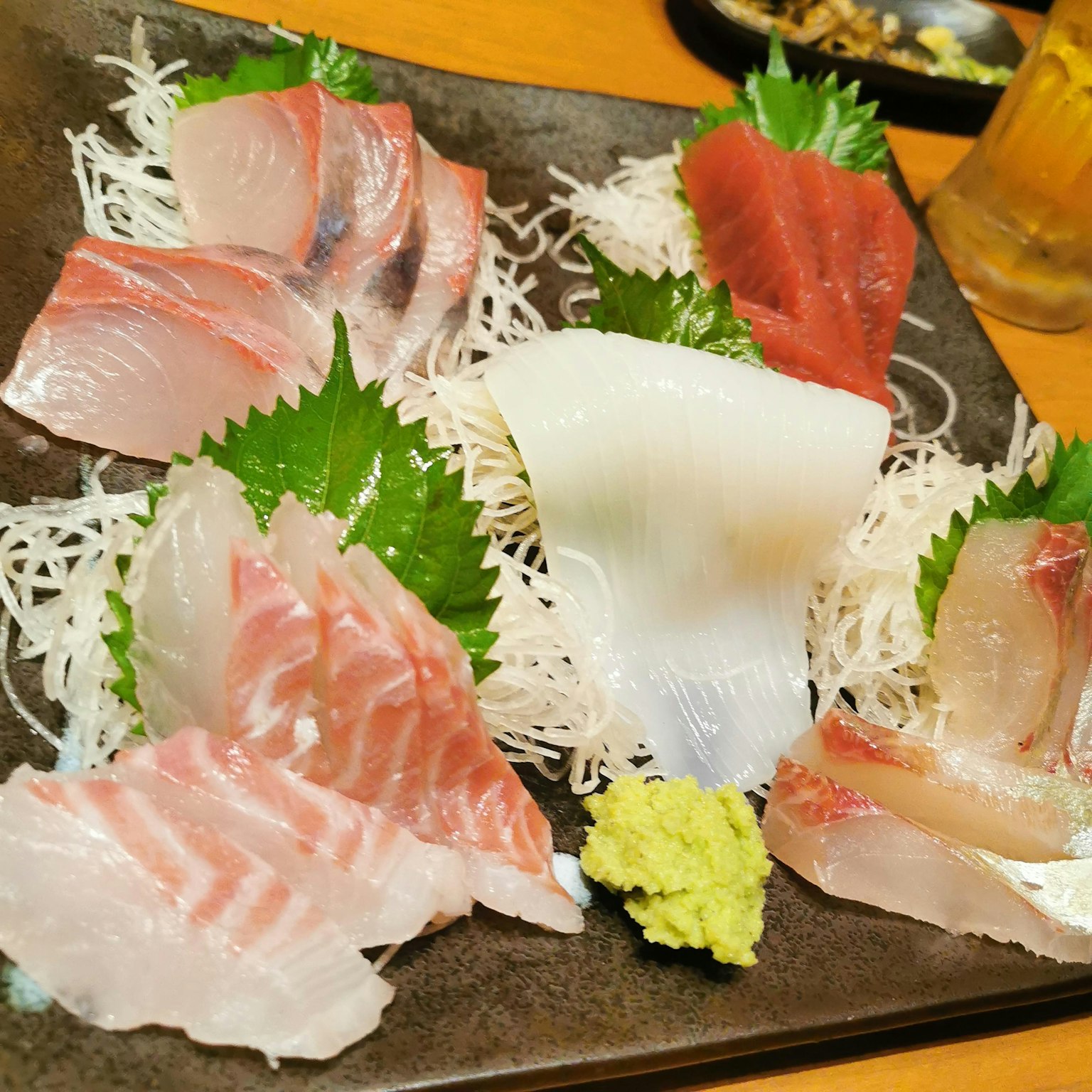 Un plato de sashimi fresco dispuesto con wasabi y guarniciones