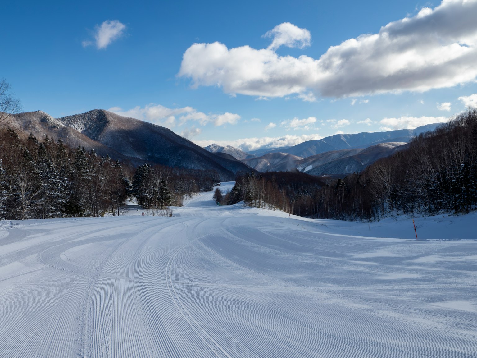 Snow-covered mountain path with a clear blue sky