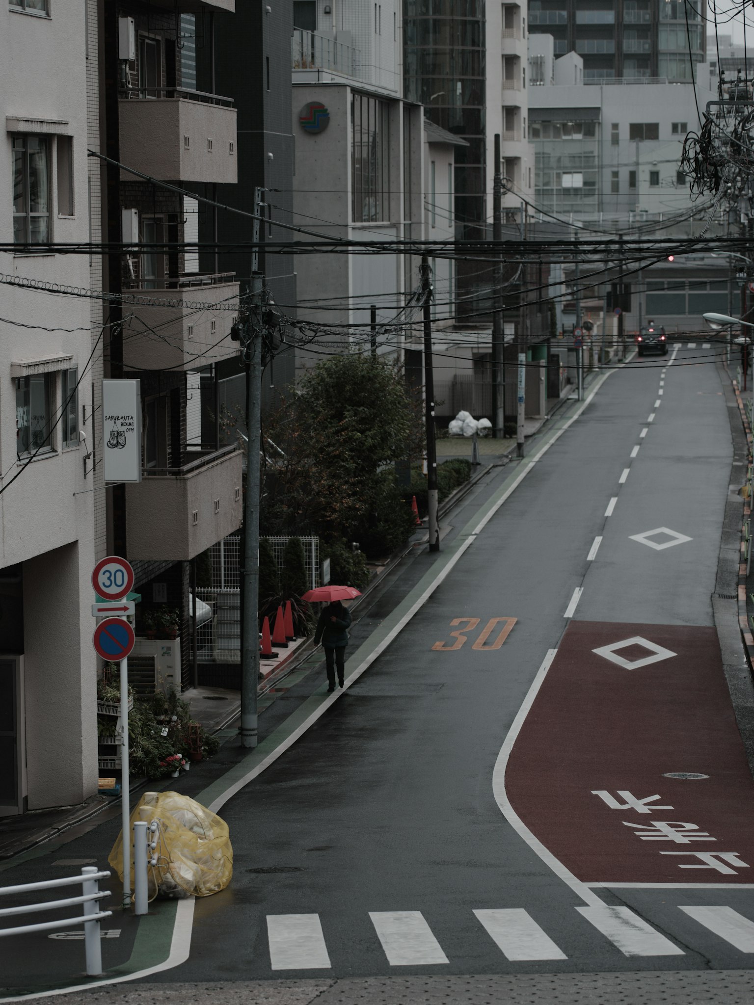 Một ngày mưa ở Tokyo với một người cầm ô và một con phố yên tĩnh